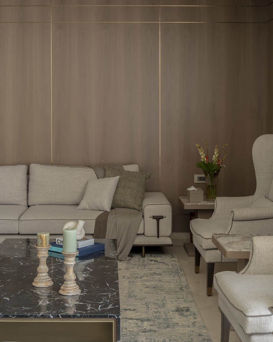 The living room, where warm timber and brass inlay hold the room in a single tonal register