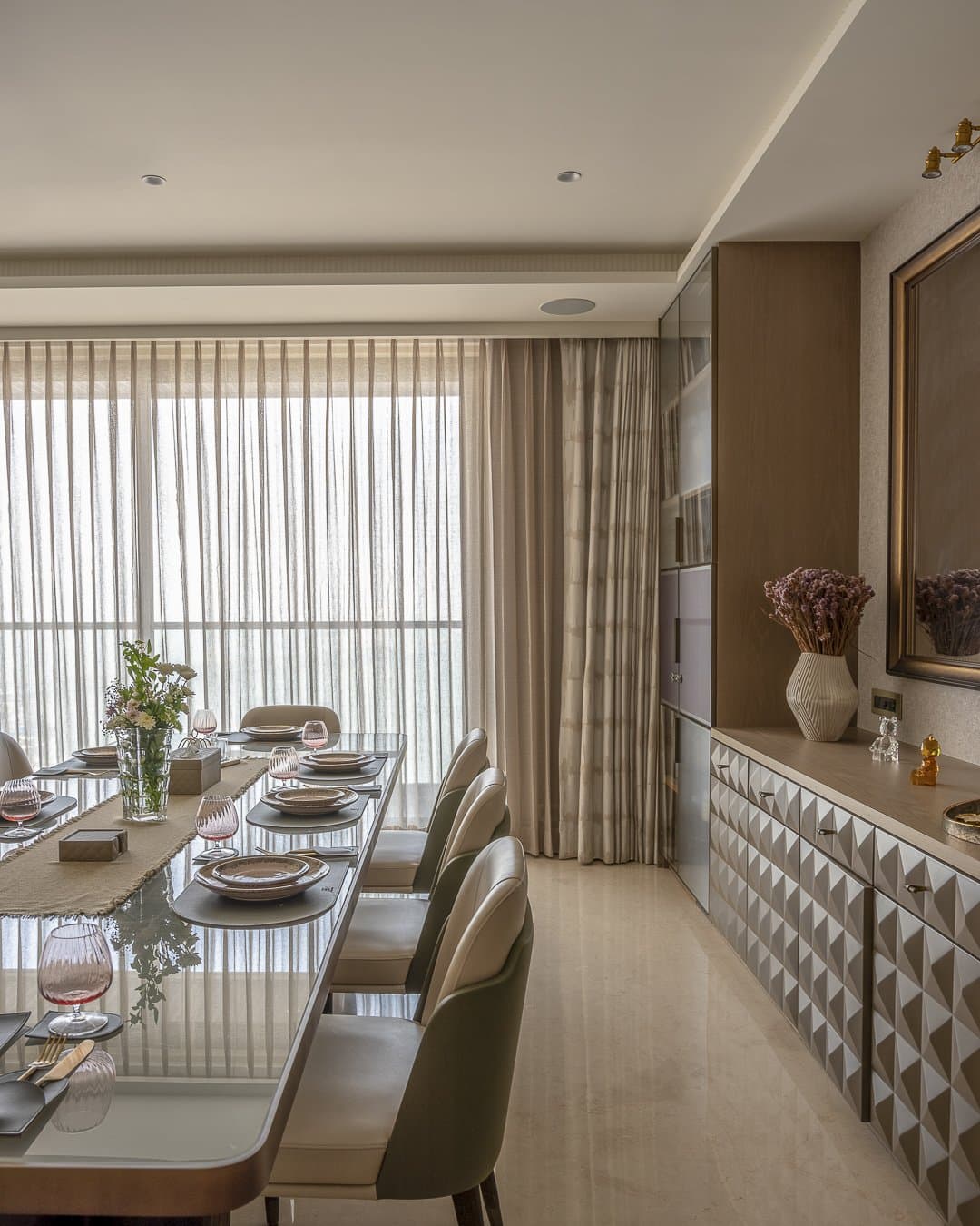 A faceted diamond-pattern sideboard provides the dining zone's sharpest textural moment