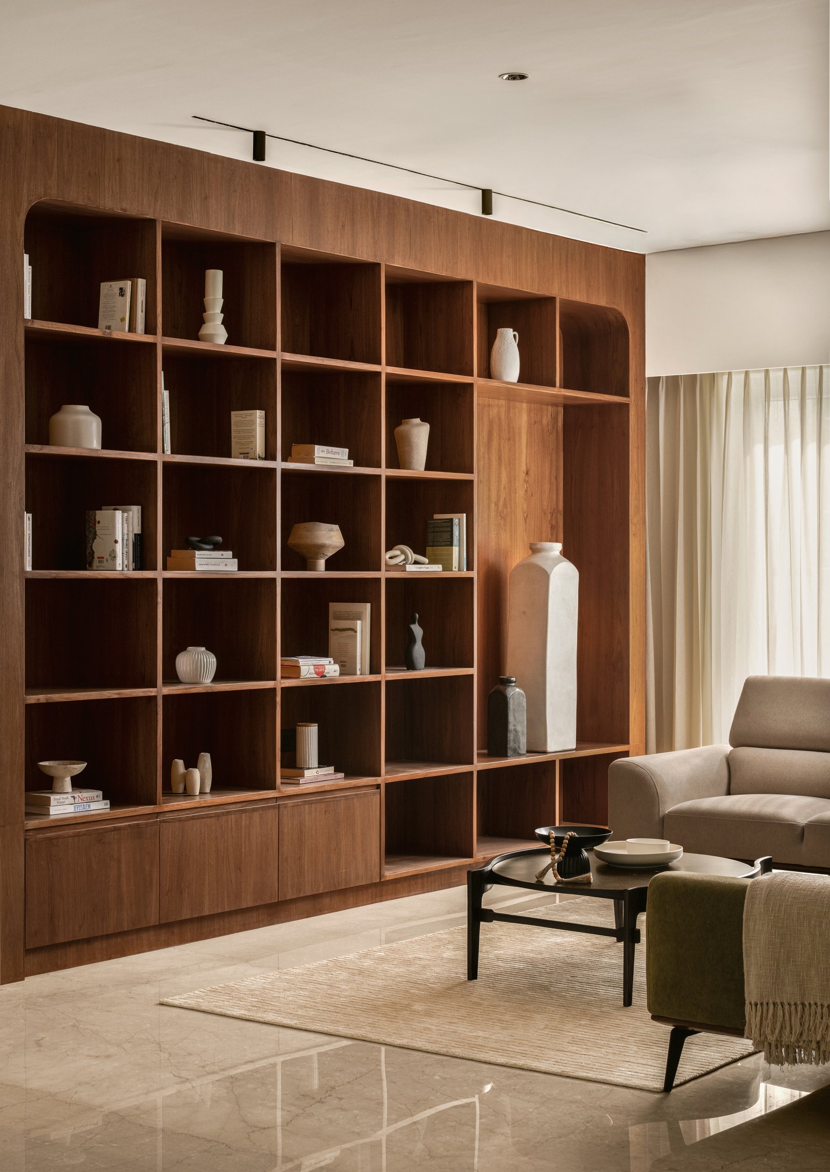 The walnut shelving wall at close range — craft, negative space, and the quiet confidence to leave cells empty