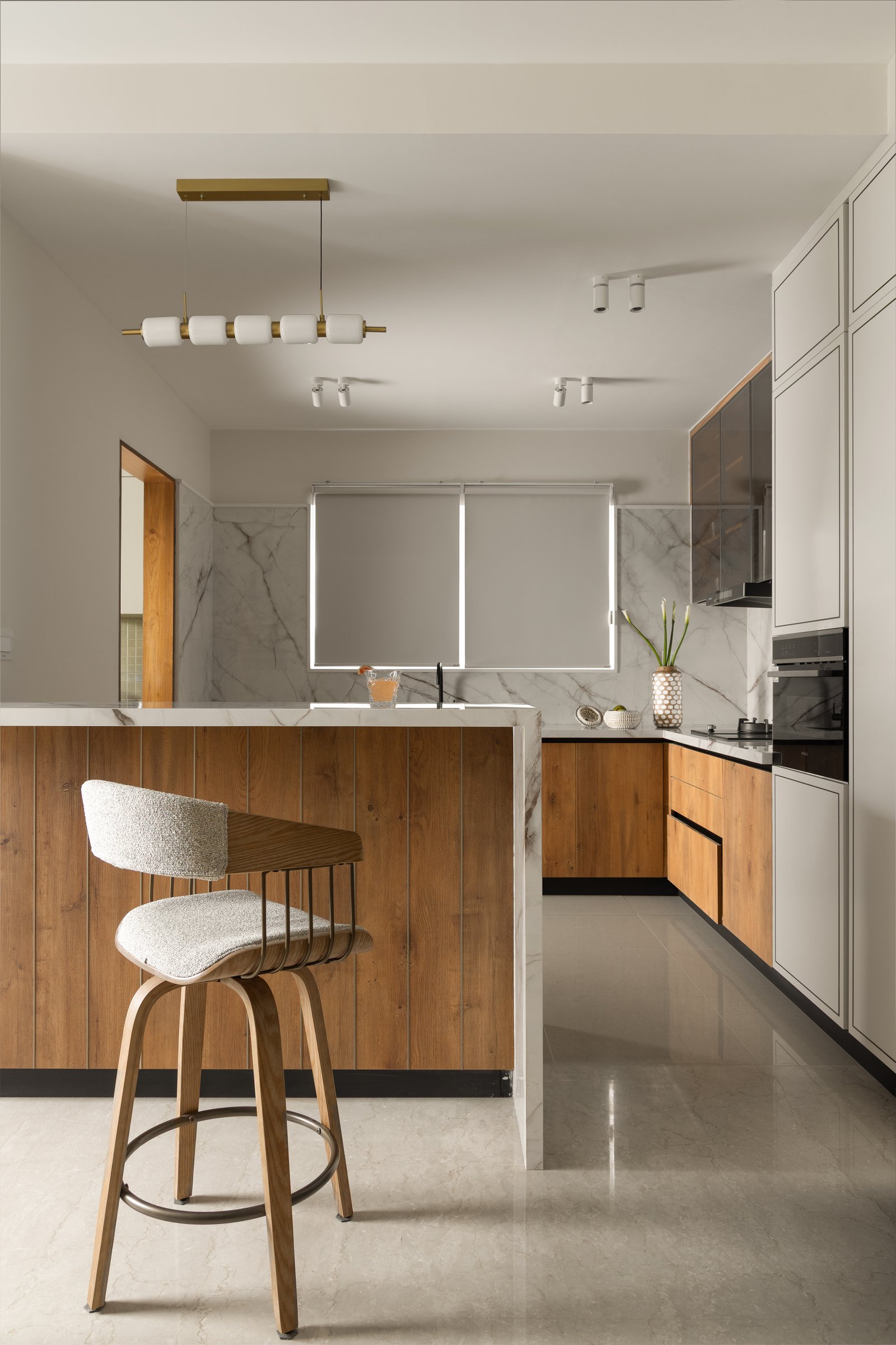 The dry kitchen: a quartz-topped island with timber base draws the living zone's palette into a functional setting