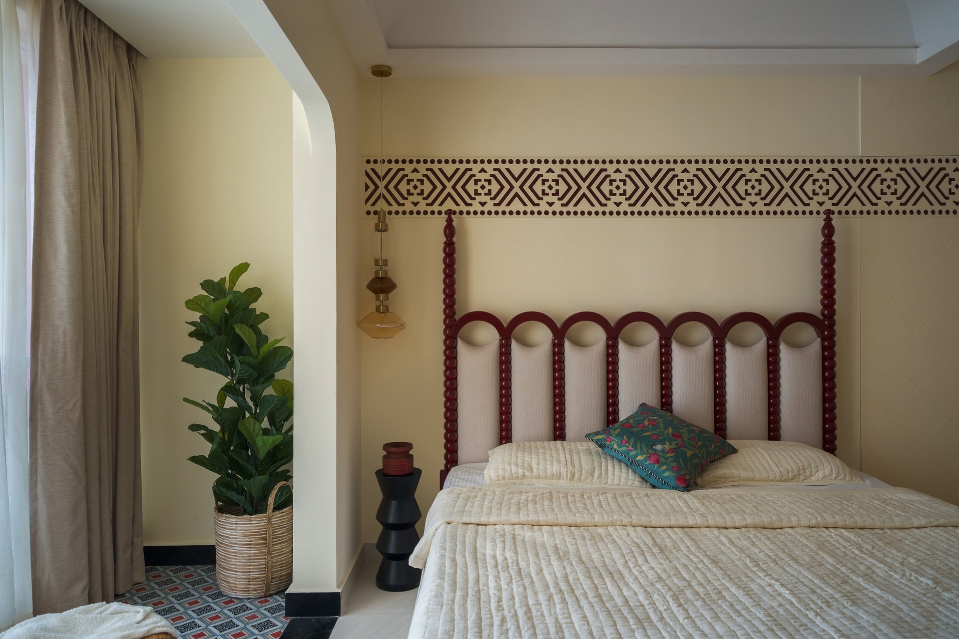 The master bedroom's custom headboard: turned maroon bobbin columns and arched upholstered panels reinterpret traditional Indian craft furniture