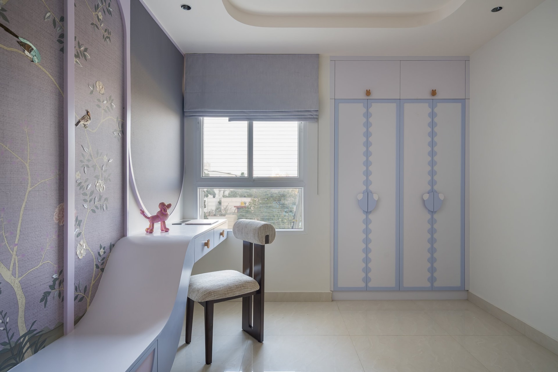 Wardrobe detailing in the child's room, with scalloped edges and playful handles adapting the home's curved grammar