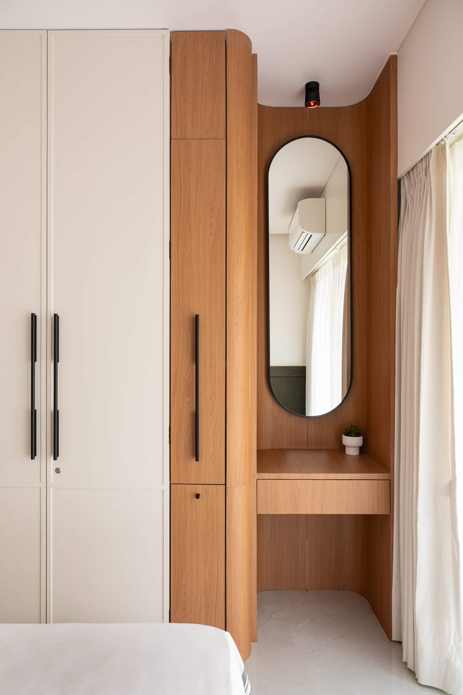The wardrobe alcove in warm timber, where storage and dressing ritual share a considered corner