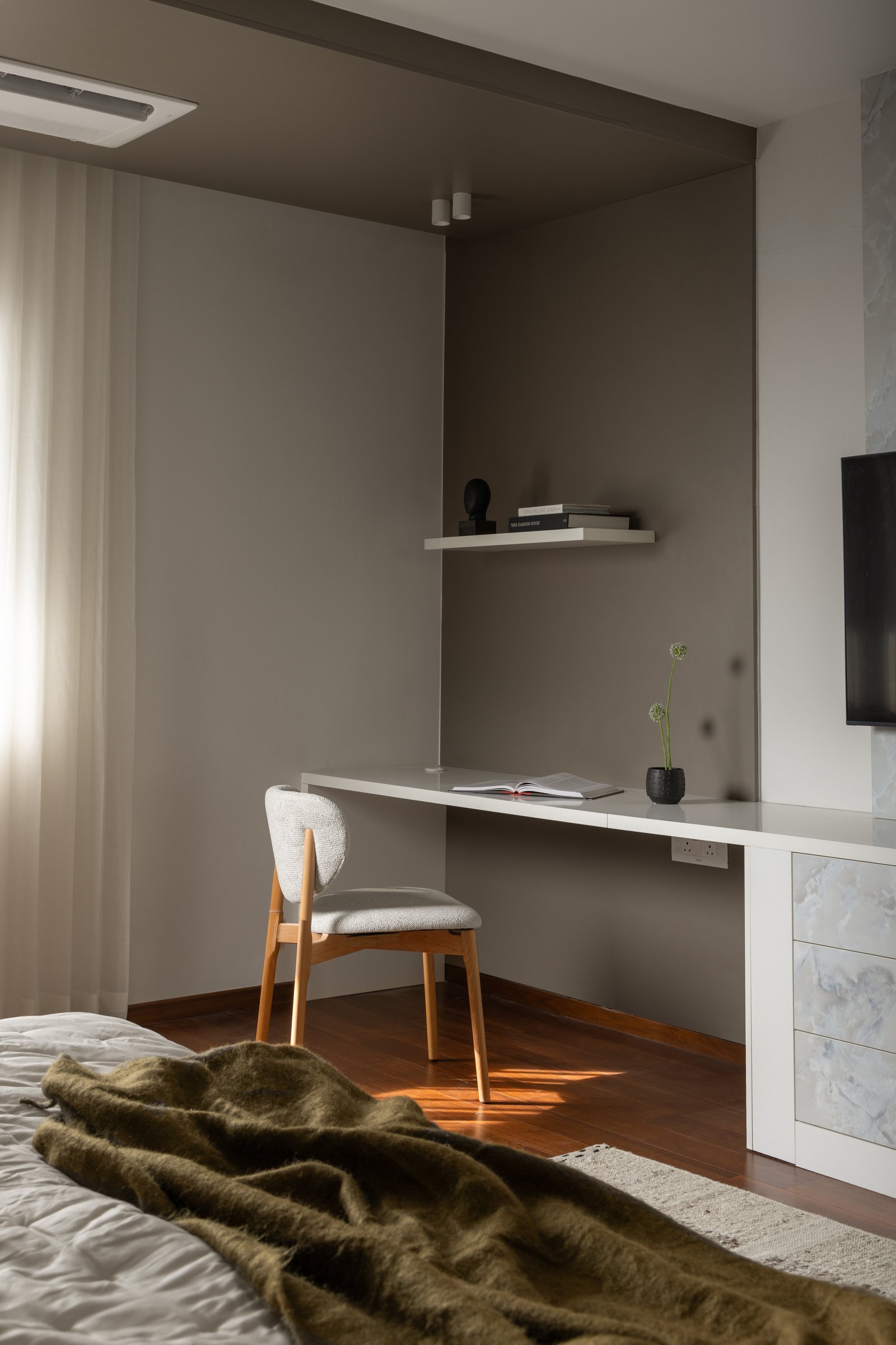 The master bedroom study nook, where taupe walls and wooden flooring establish a tone of measured calm