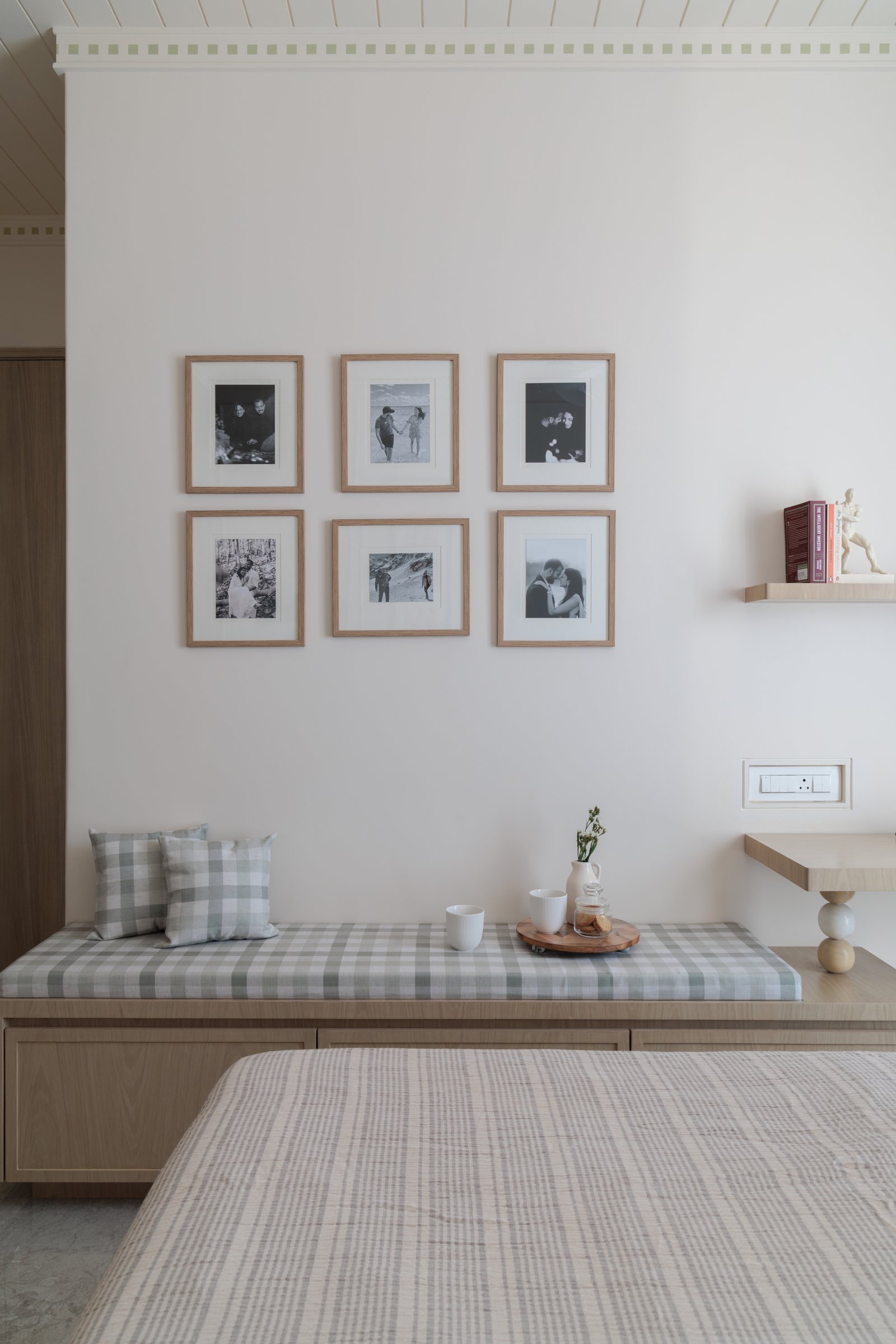 A bench seat beneath the gallery wall doubles as a window perch, a space where function and sentiment share the same surface