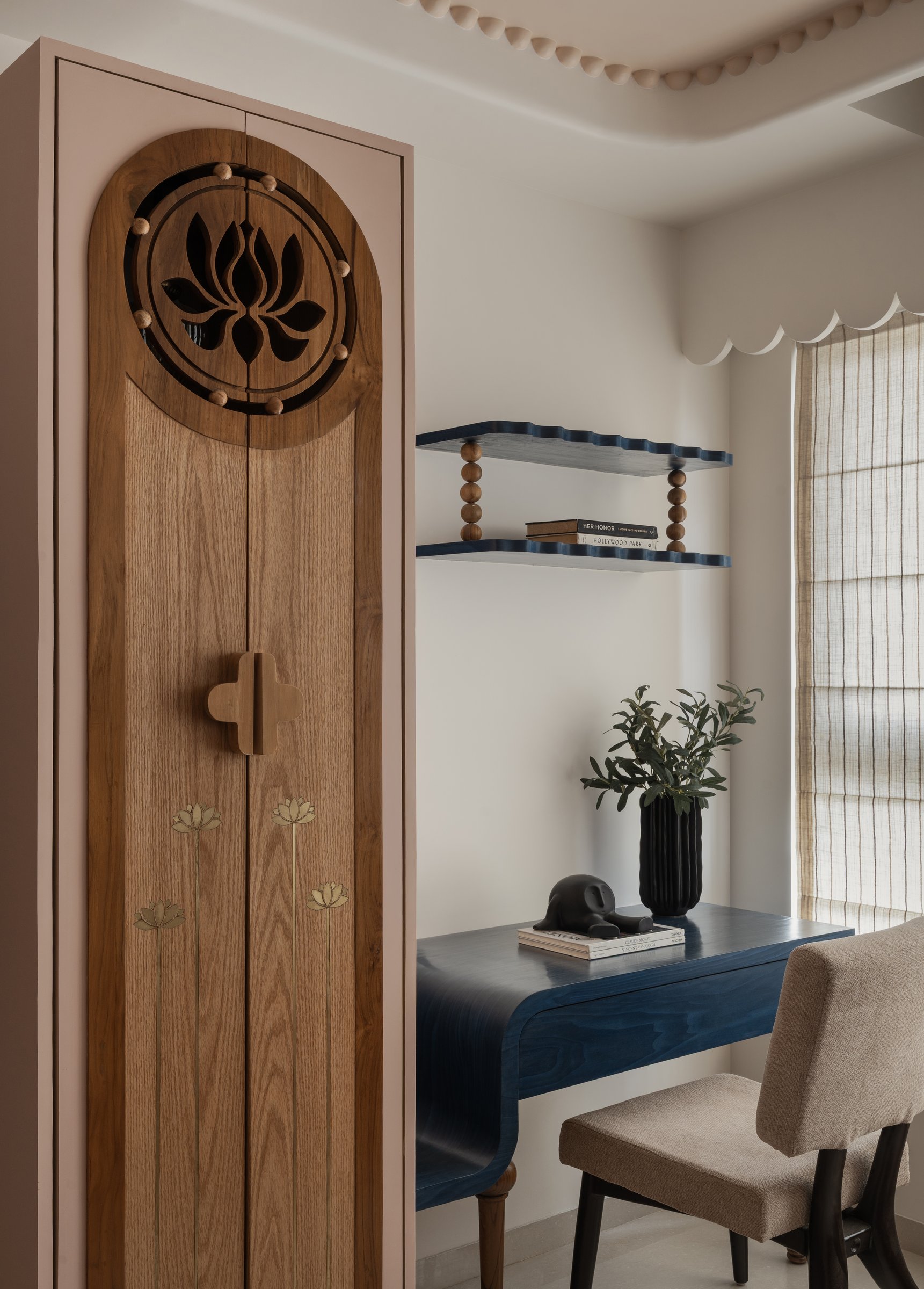 In the children's study corner, a carved lotus pooja-style cabinet shares a wall with an indigo writing desk