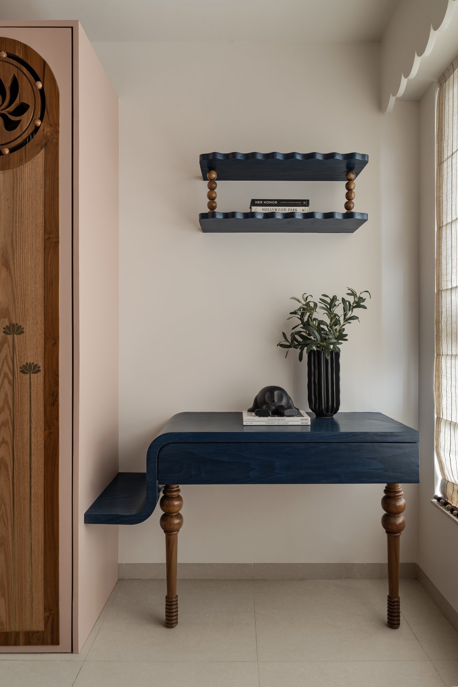 The bespoke desk meets a scalloped indigo shelf in the home's most colour-confident moment