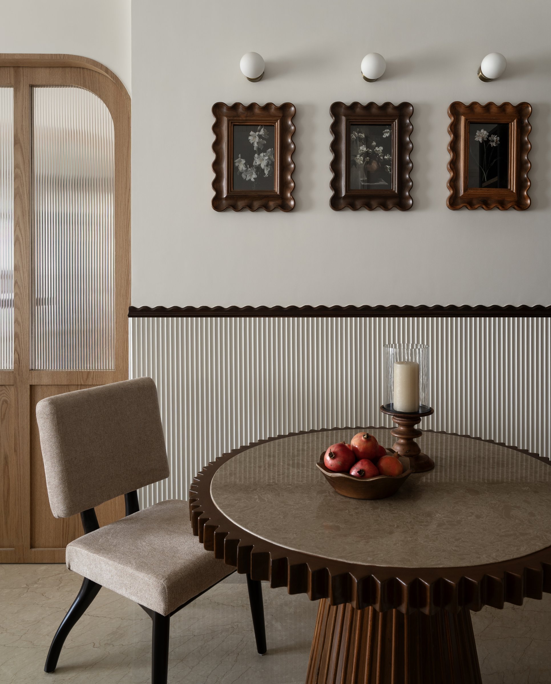 The dining table behaves like a piece of sculpture, its sunburst-fluted base reading as its plinth