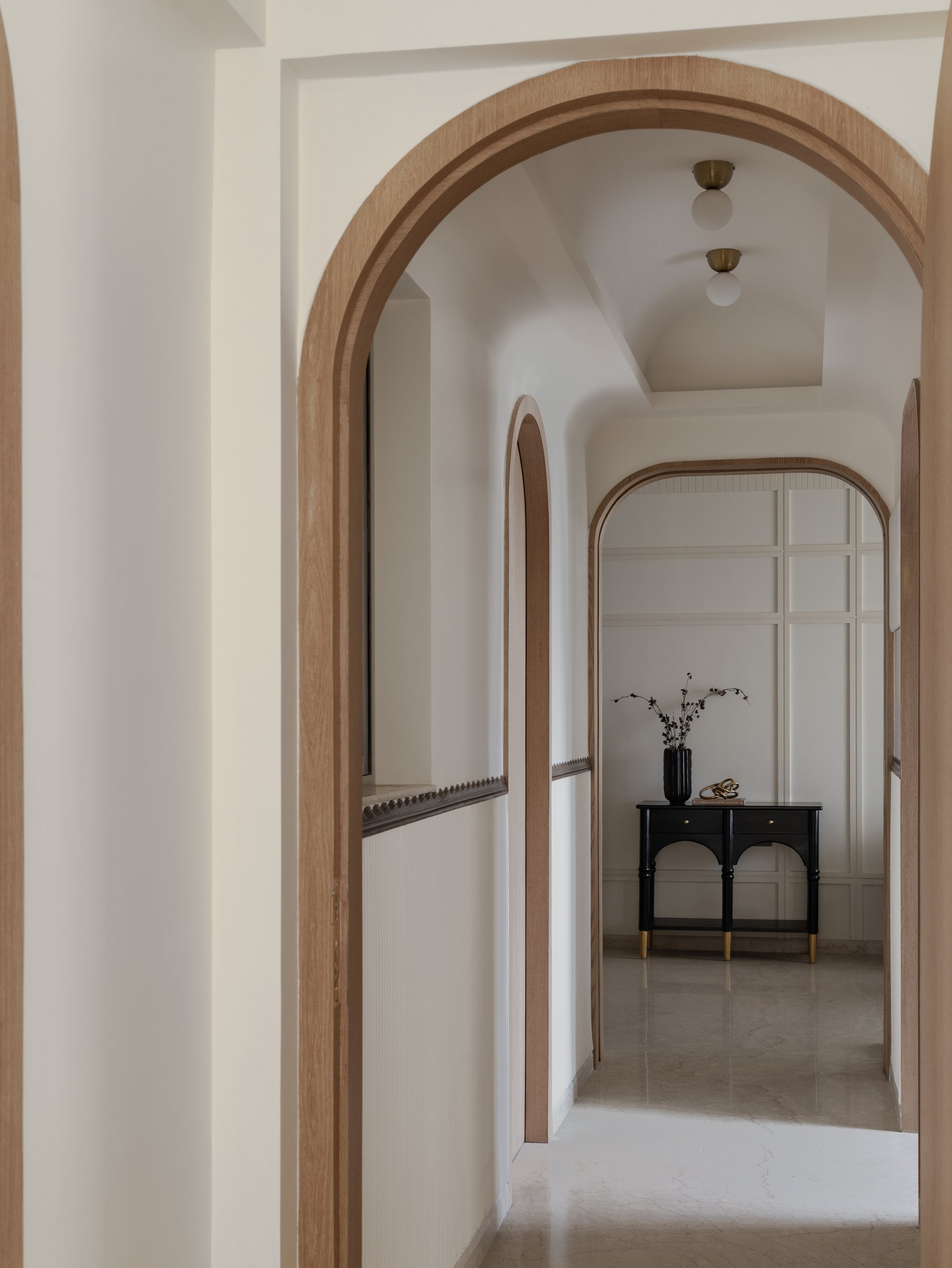 A sequence of graduated arches turns the corridor into a cloistered procession