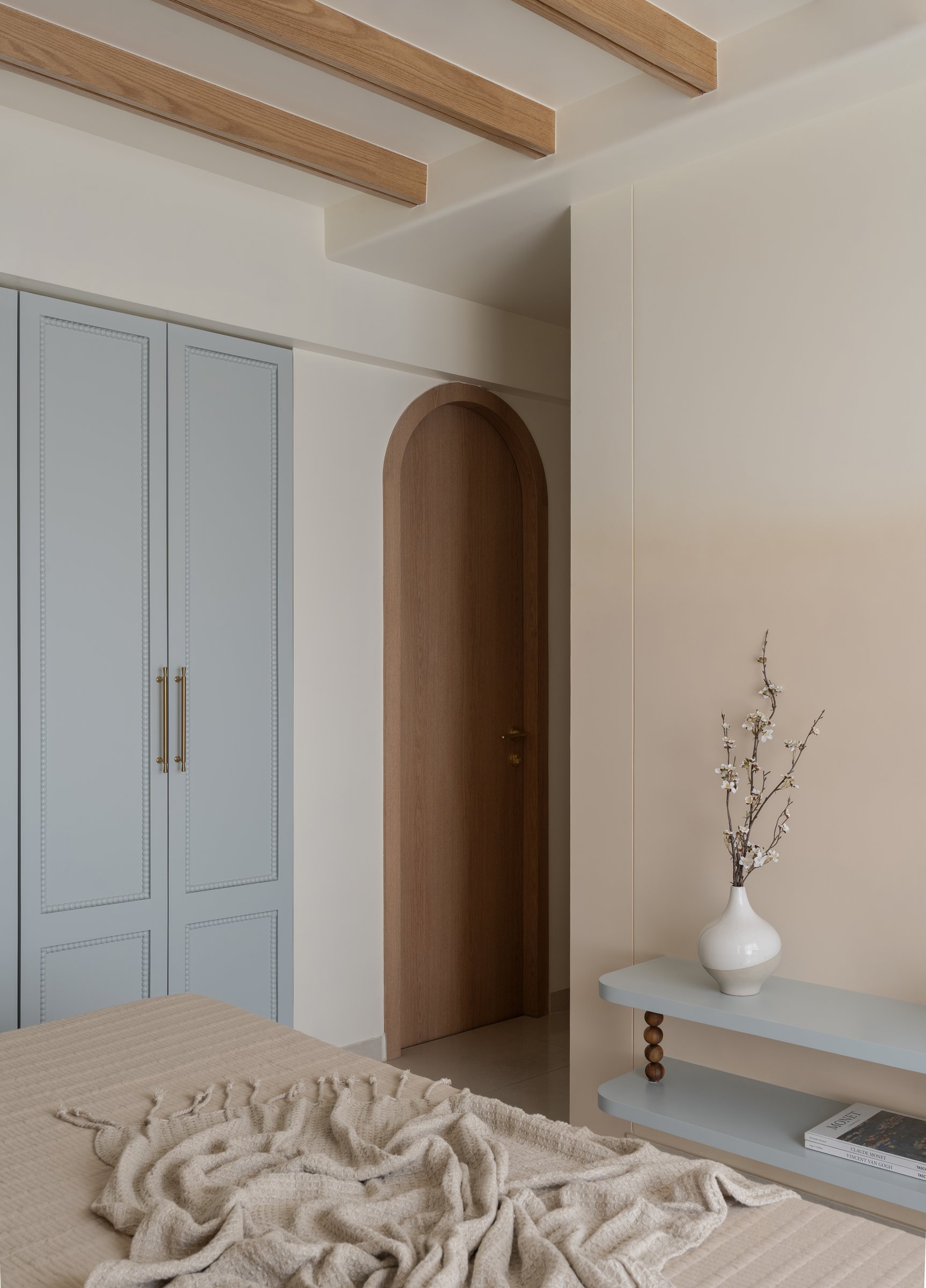An arched timber door leads from the master into the bath, the exposed beams organising the ceiling into rhythmic bays