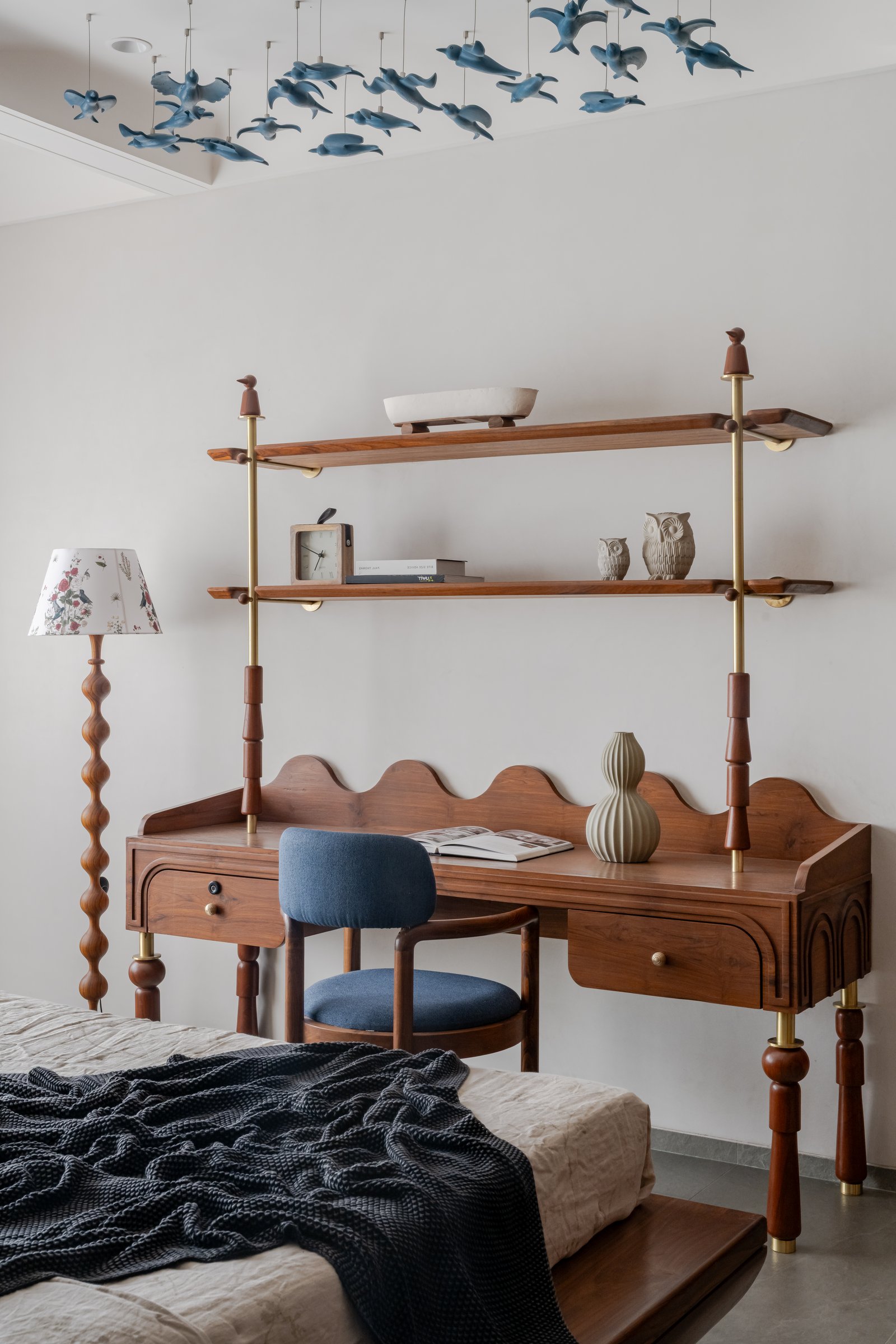 The scallop-edged timber desk and suspended blue ceramic birds in the study nook