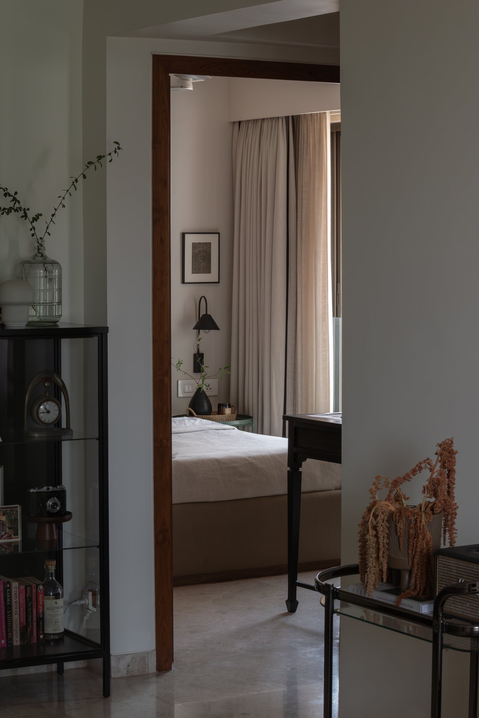 A view from the living room into the master bedroom, the home's spatial transitions handled as gentle dimmings of tone
