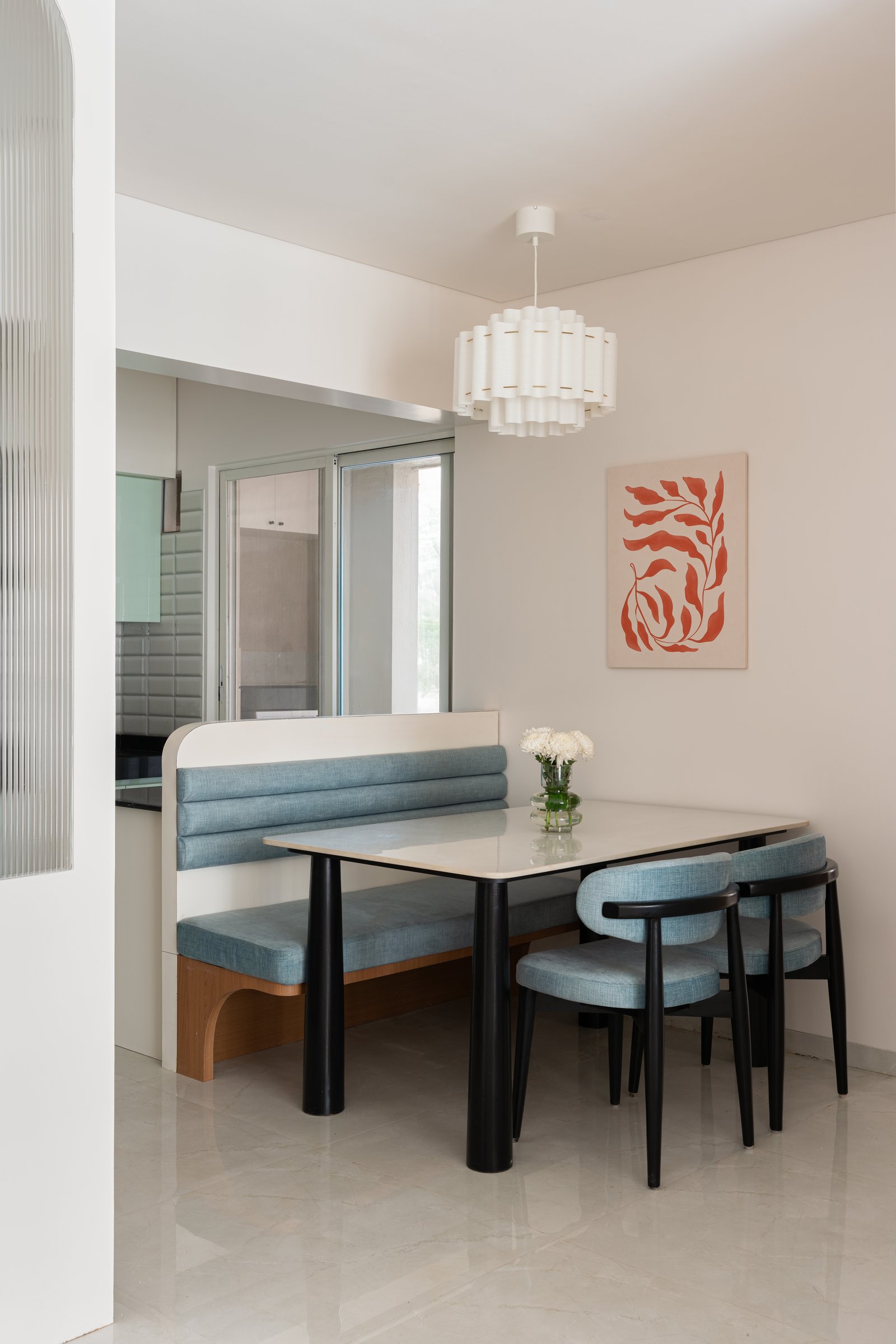 The dining nook: a built-in banquette and cylindrical pendant create intimacy within the open plan