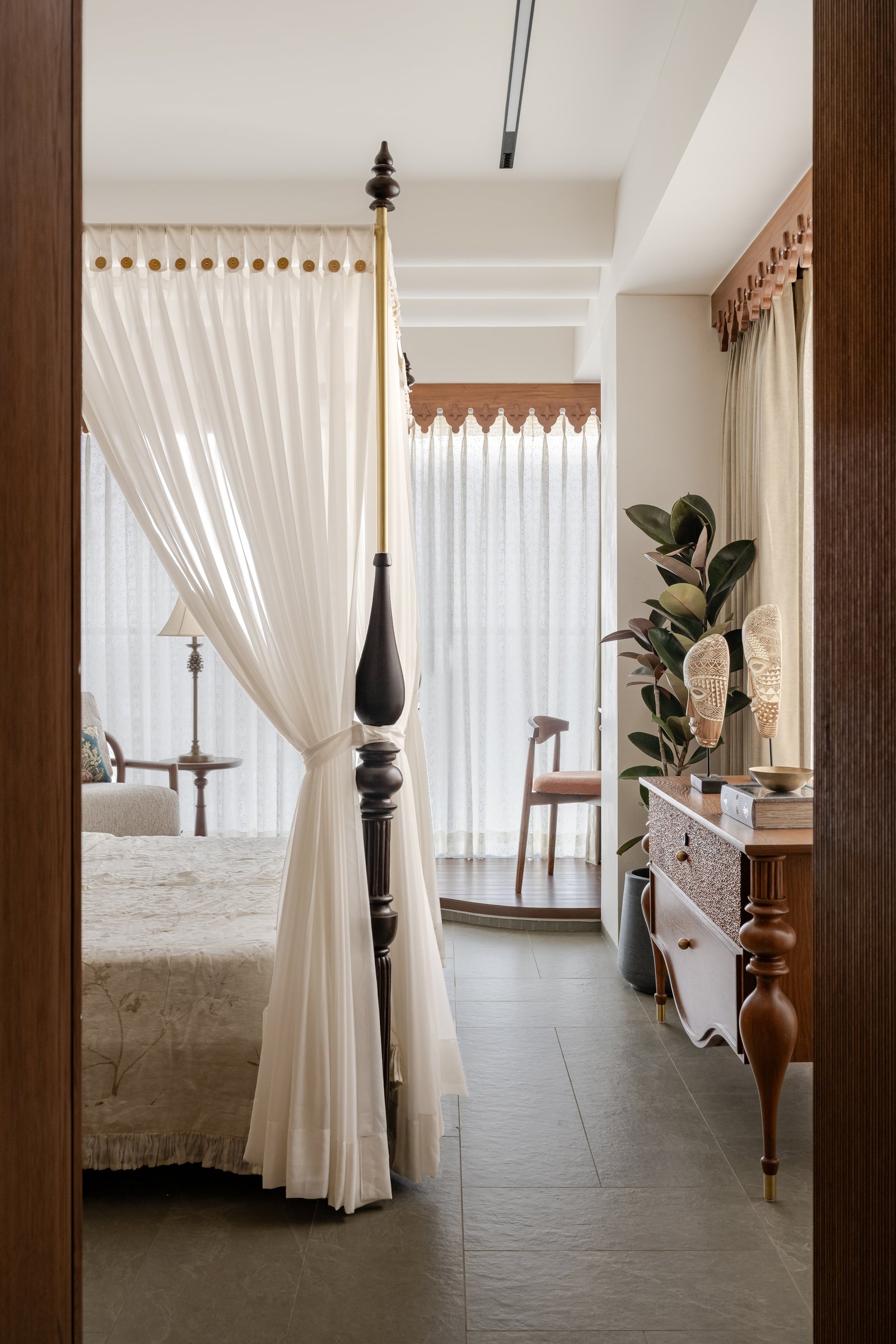 Wing B's master bedroom, a four-poster in dark timber and white curtains evoking colonial-era canopied beds