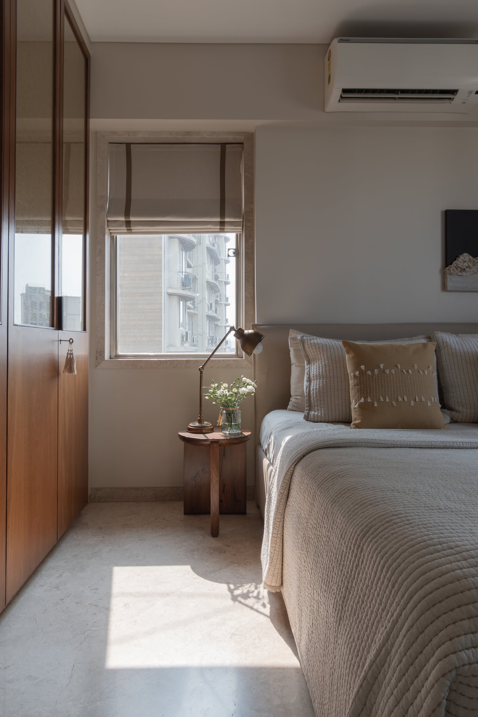 A wardrobe wall in honeyed wood with caned upper panels, the room's single decorative gesture allowed to stand alone