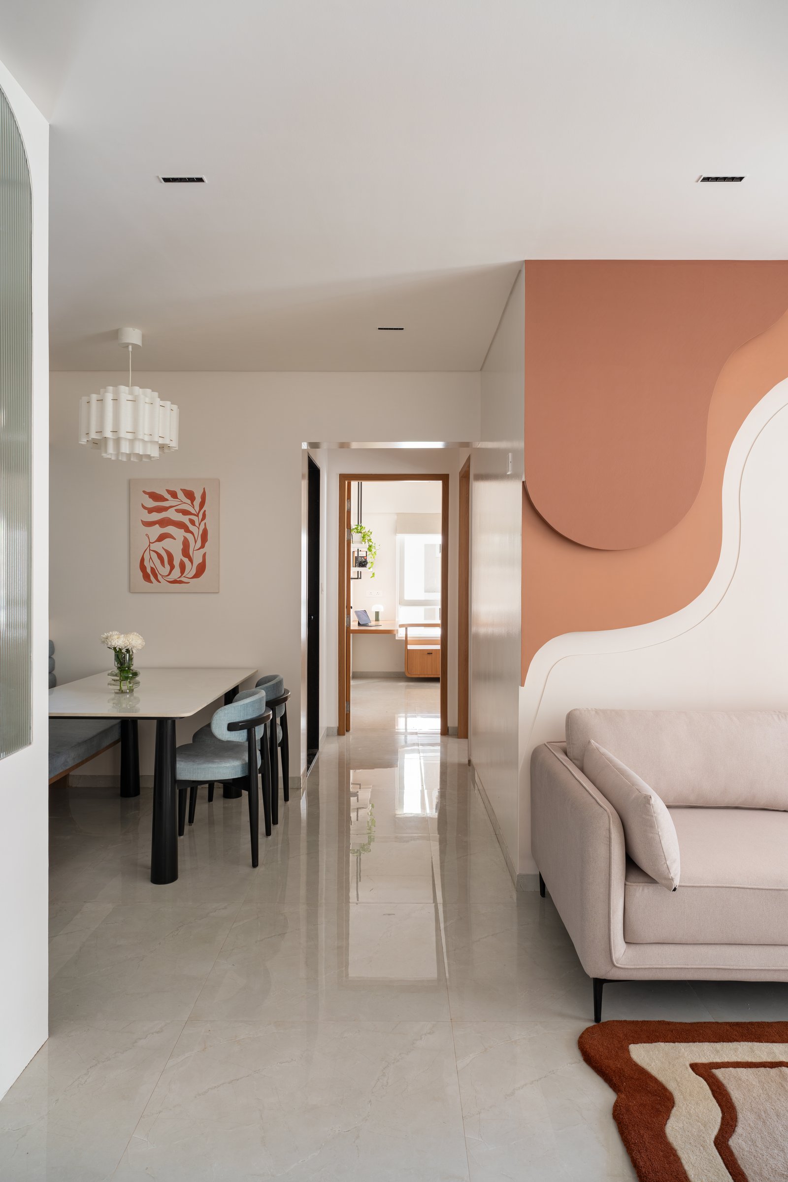 Living and dining share a single open volume, with the corridor drawing the eye through to the bedroom beyond