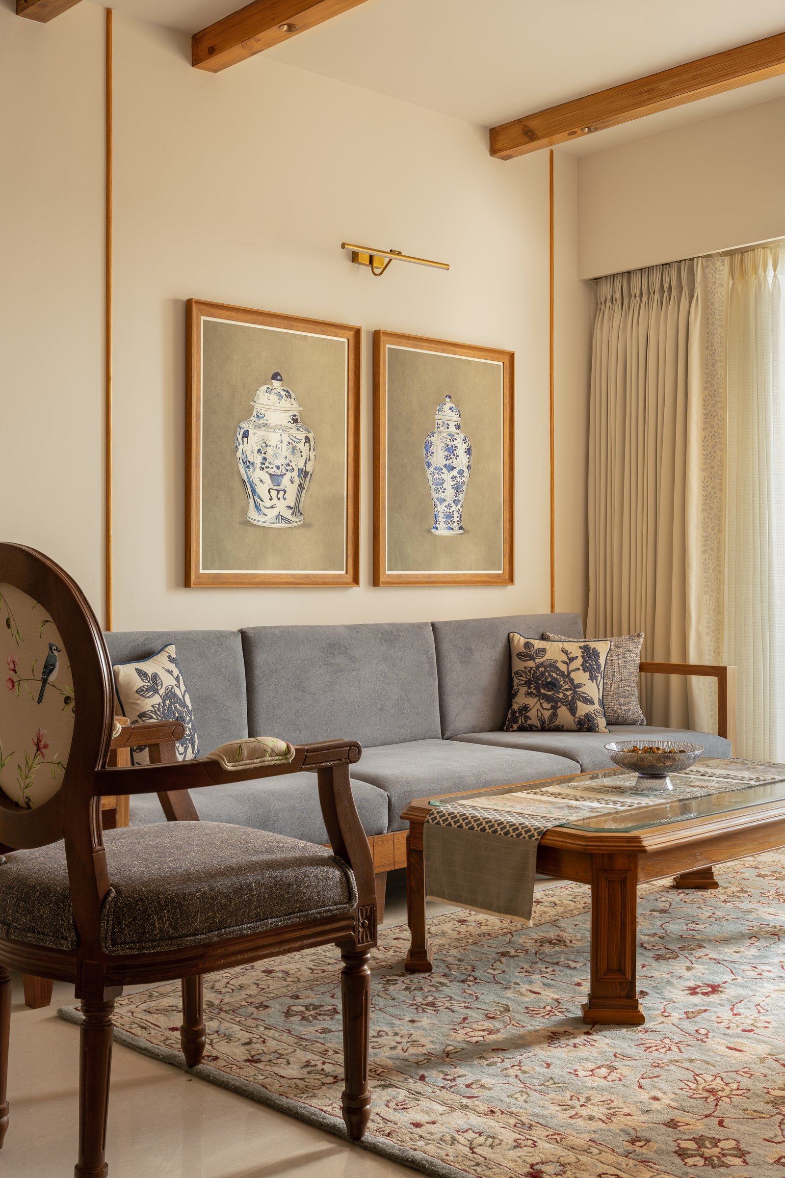 A closer view of the living room's sofa wall, where framed porcelain-vase illustrations anchor the tonal palette