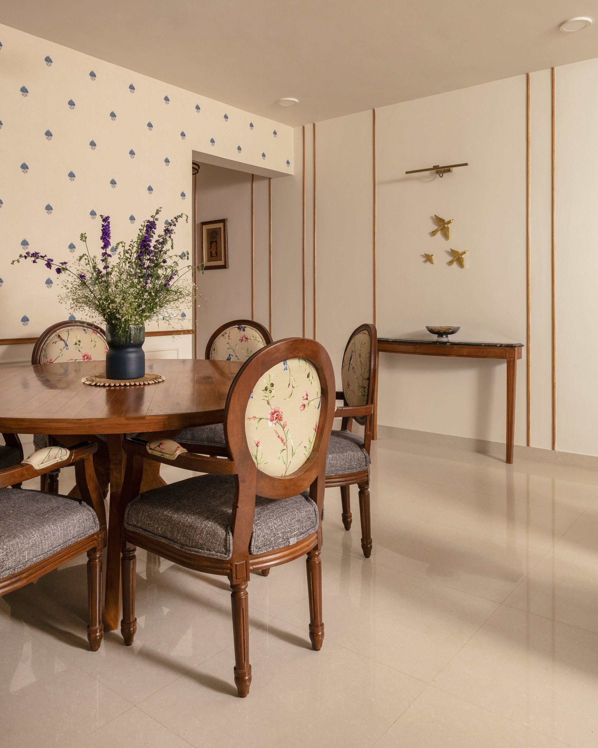 The dining table seen against the foyer corridor beyond, revealing how sightlines connect the home's public spaces