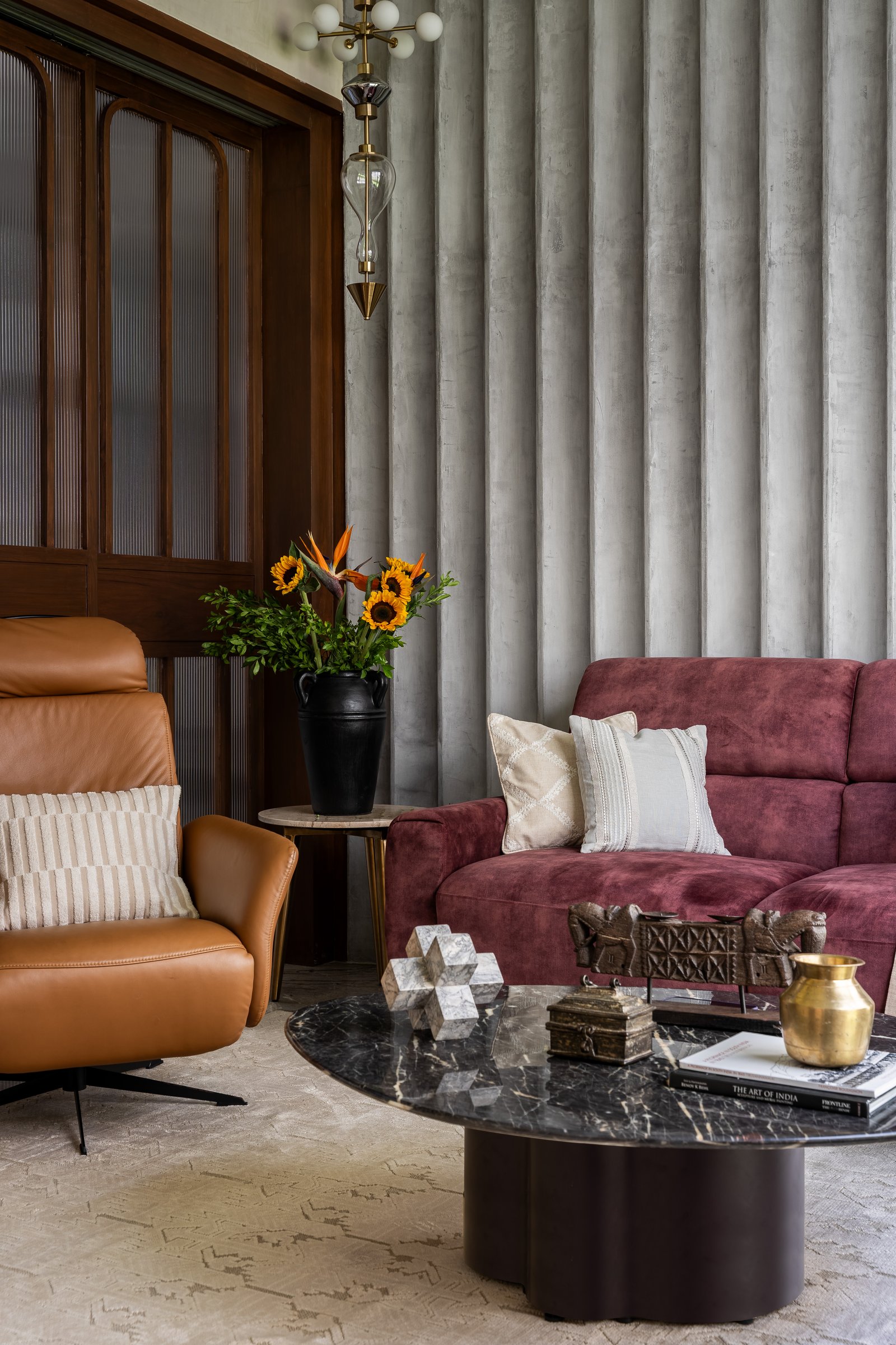 The second living zone, anchored by a fluted concrete wall whose ribbed verticality lends the room a sculptural backbone