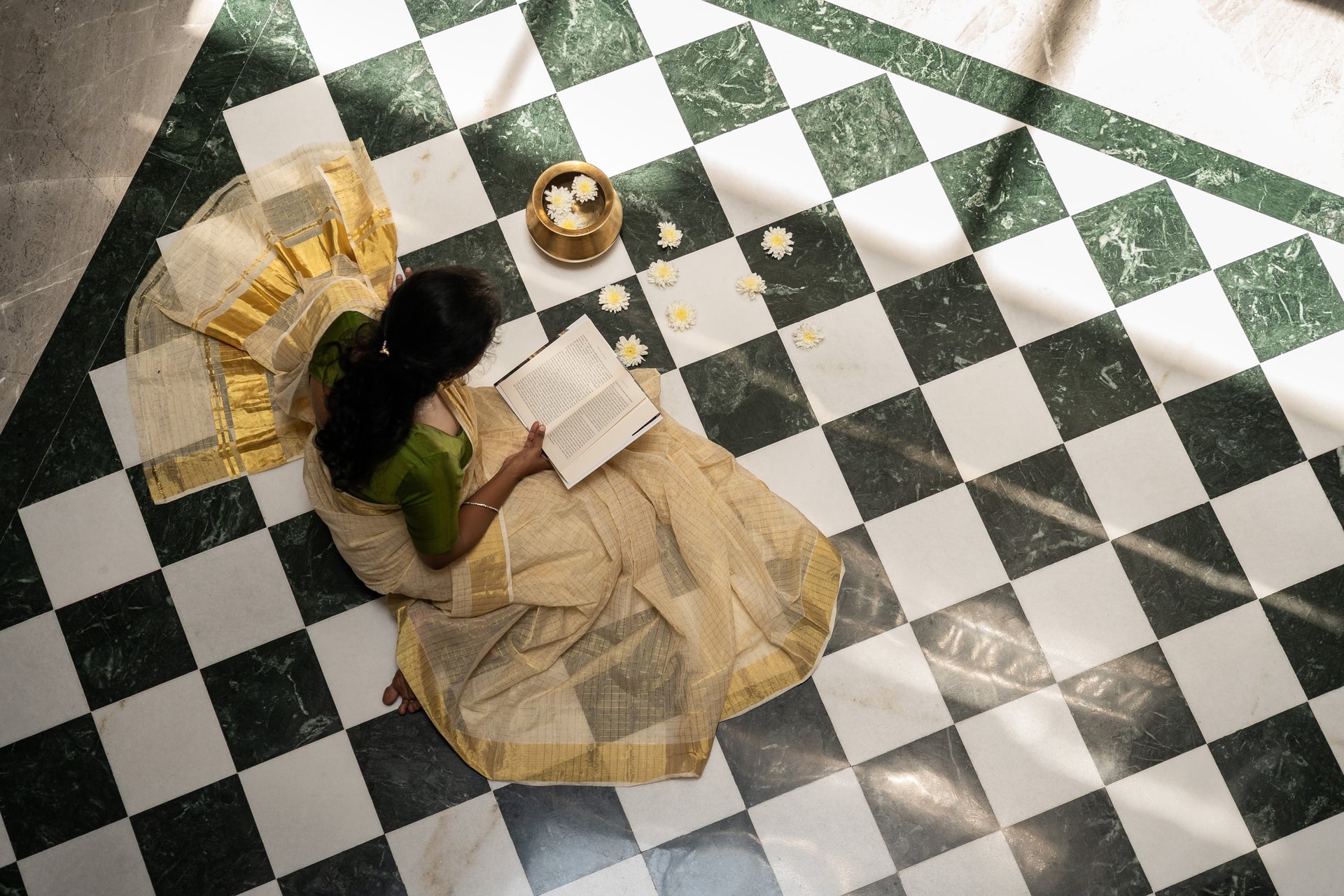 The foyer floor breaks into a checkerboard of deep green and white marble, light becoming the room's only event