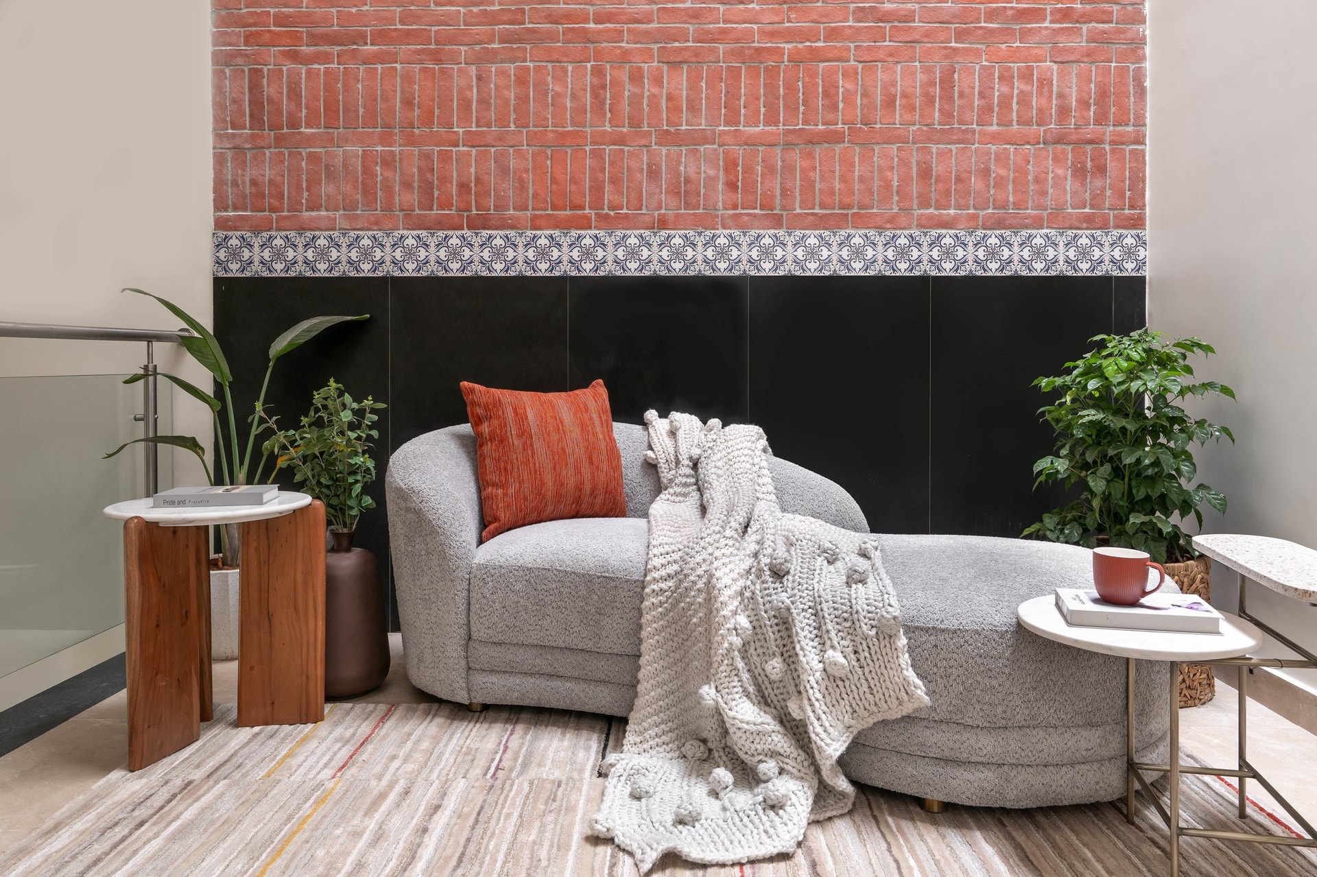 A landing reading retreat where exposed brick, patterned tile and dark stone stack like geological layers