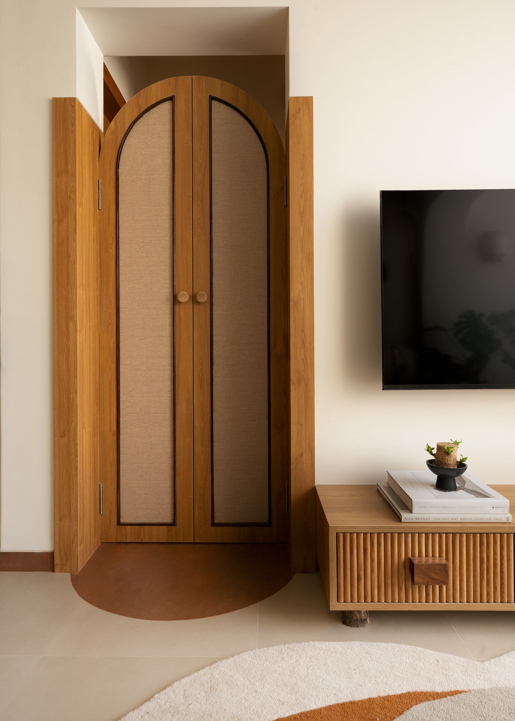 The arched cane-and-timber doorway, with its terracotta threshold, marks the passage from public to private