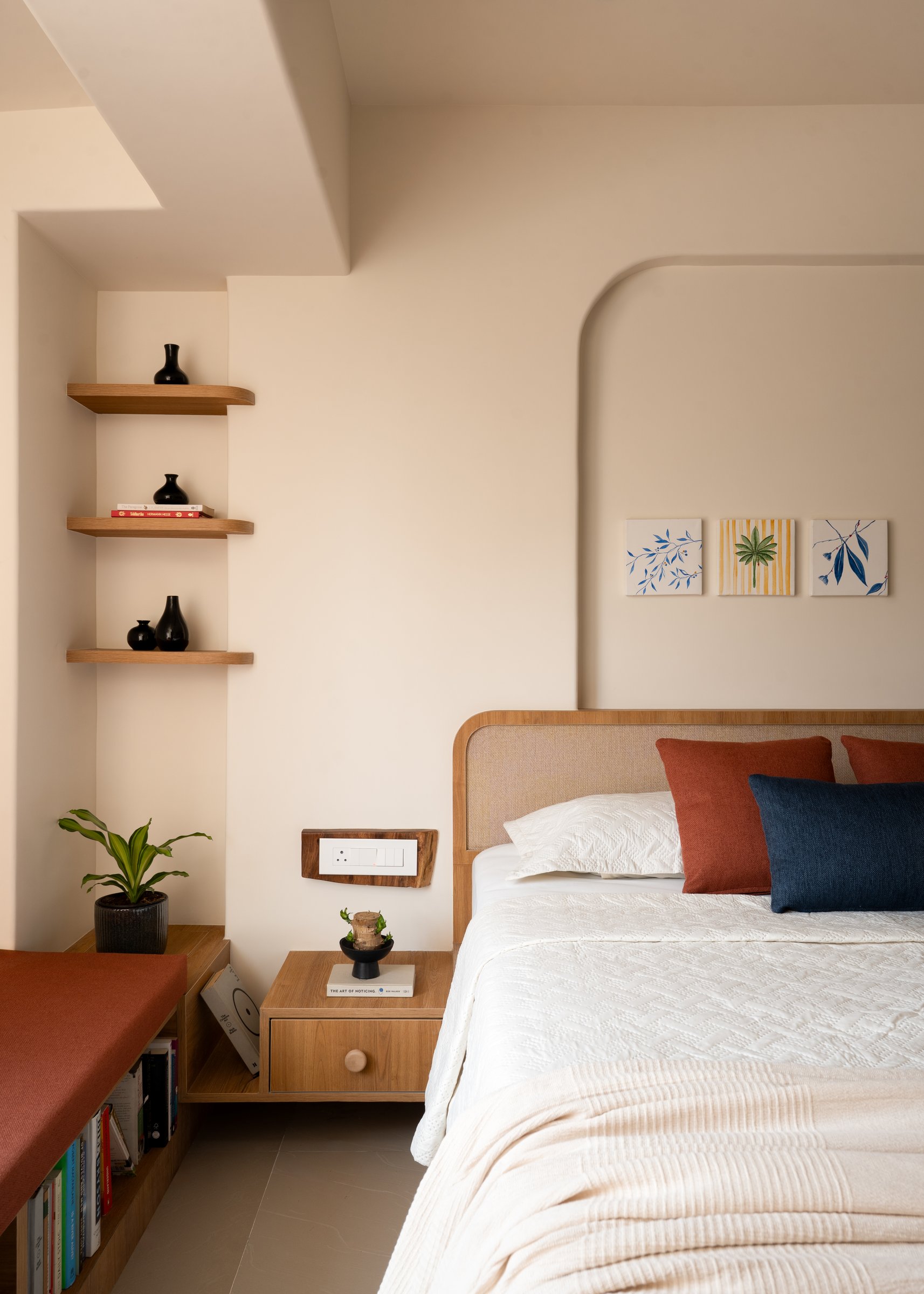 Recessed timber shelves hold a quiet congregation of dark vessels