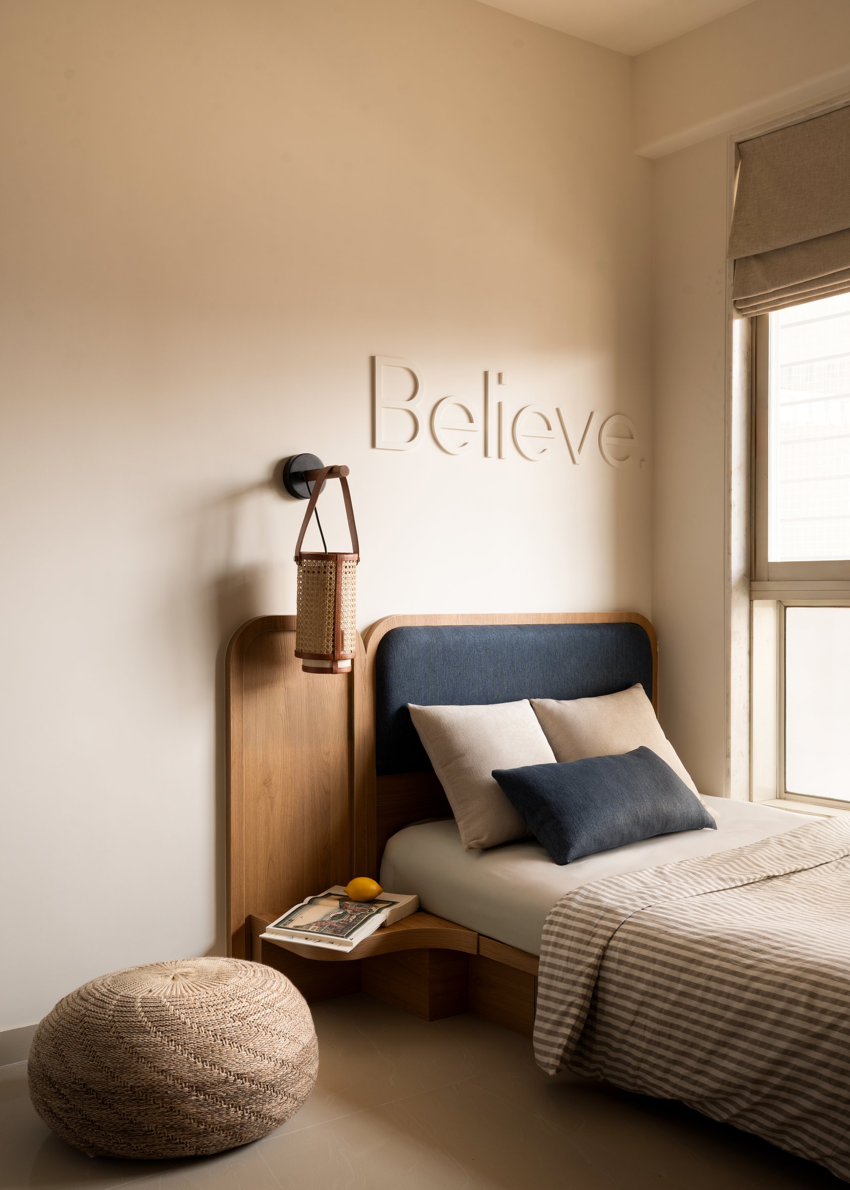 The second bedroom, where the word Believe in pale relief replaces the predictable vocabulary of a children's room