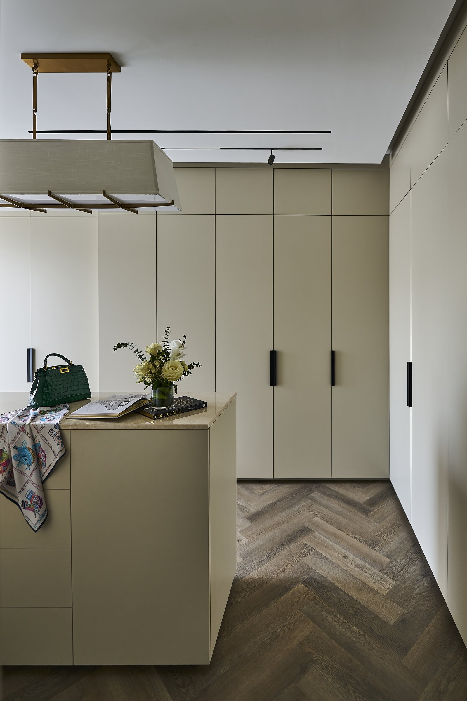 The walk-in closet, treated as the suite's most personal room, with travertine and herringbone wood