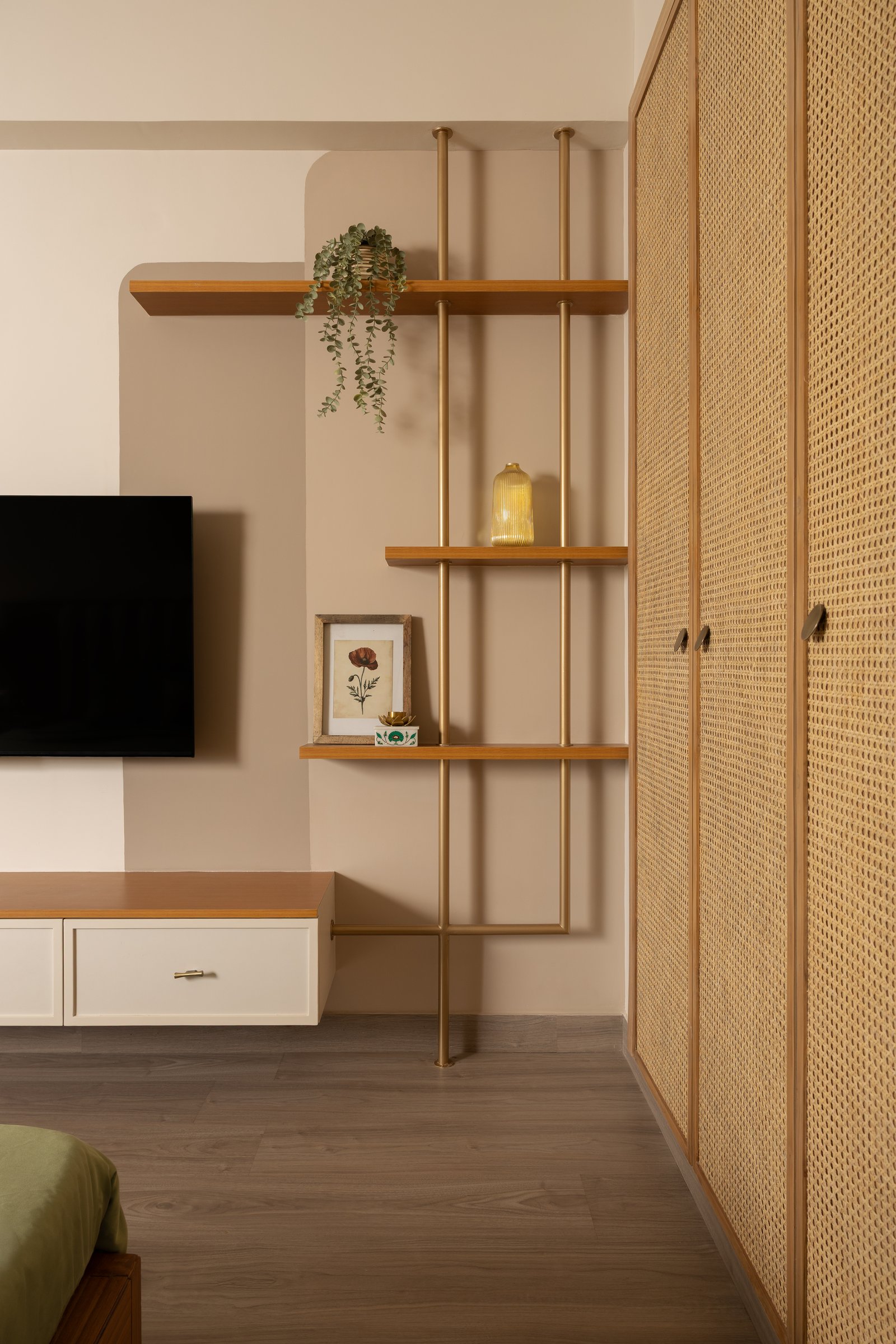 Cane-panelled wardrobes and a brass-and-timber open shelf bring texture and breath to the master bedroom's storage wall