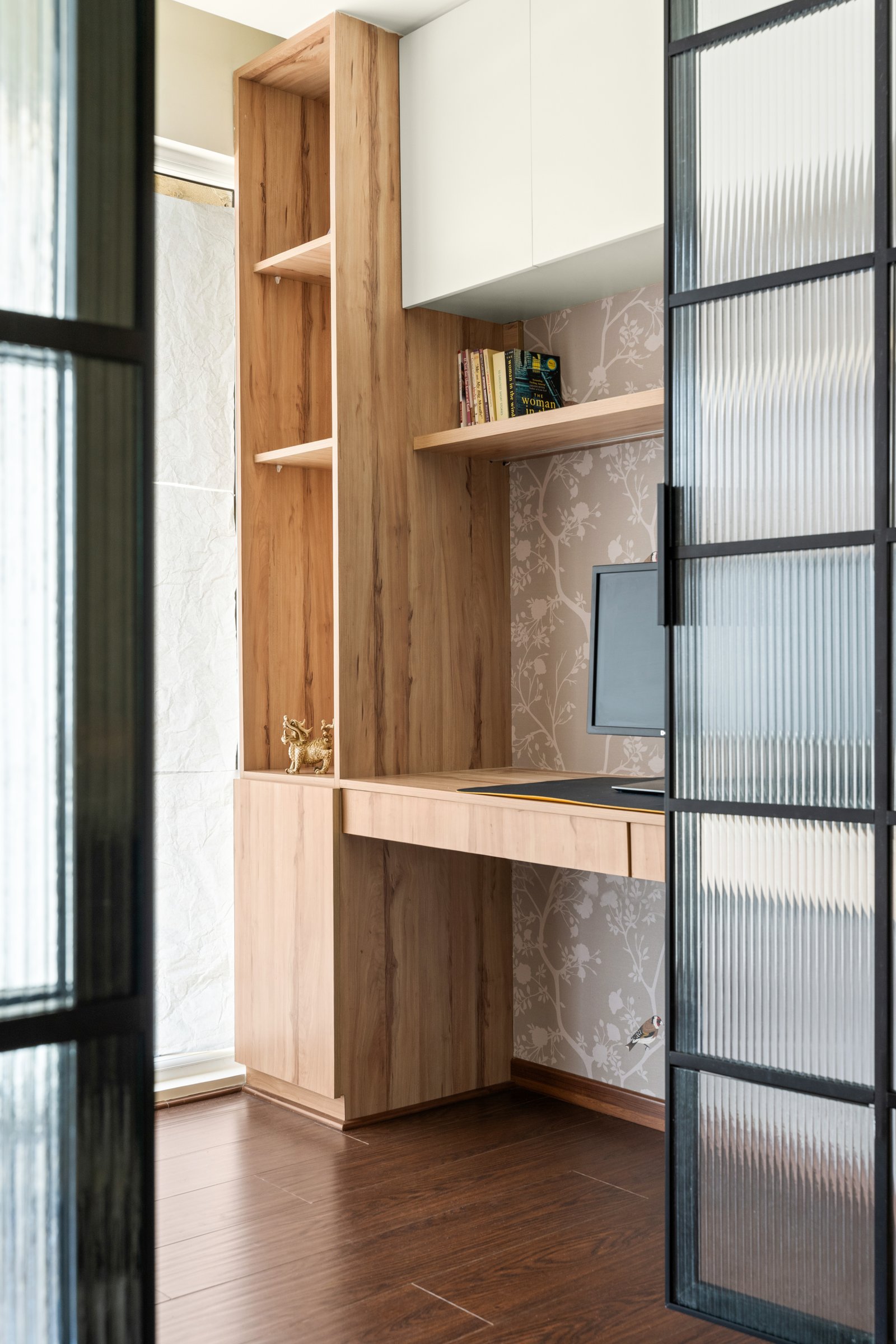 Walnut flooring introduces the upper level's only deeply dark surface, a deliberate counterweight