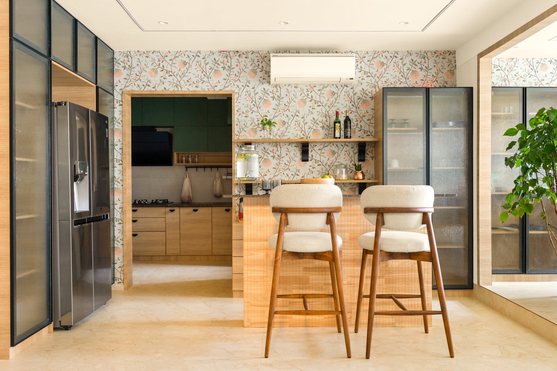 The dining counter, where fluted-glass cabinetry and a botanical wallpaper register as the home's most social gesture