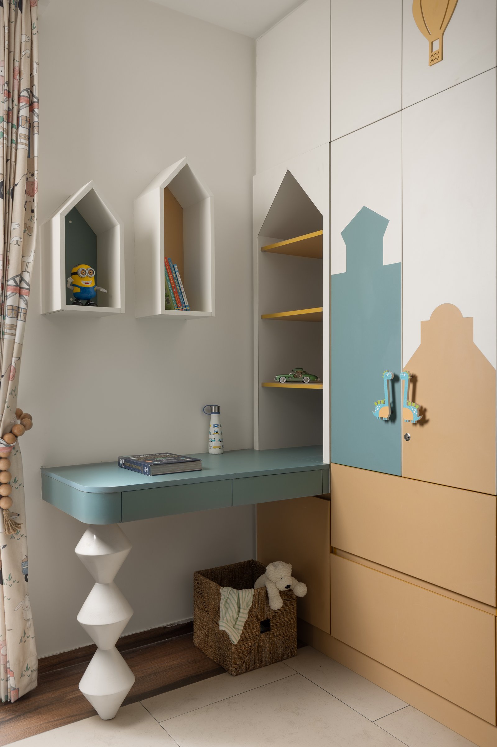 House-shaped niches and silhouetted wardrobe doors carry the room's playful language across study and storage