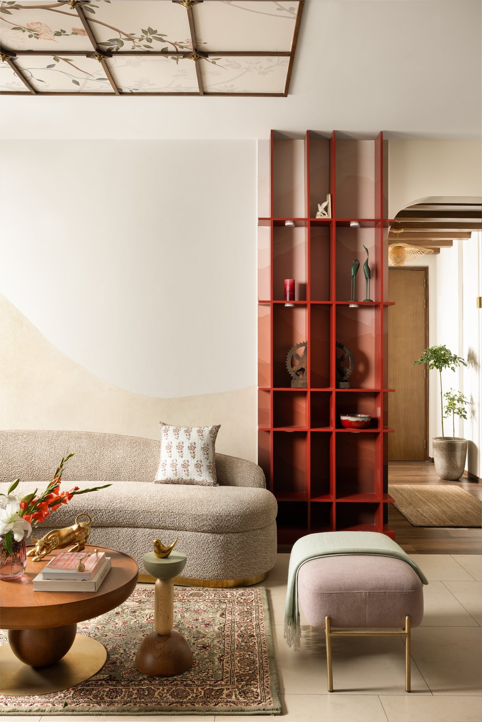 The living room's vermilion shelving unit, set against an ombre-toned wall, makes the project's central argument: heritage and contemporary form occupying the same frame without compromise