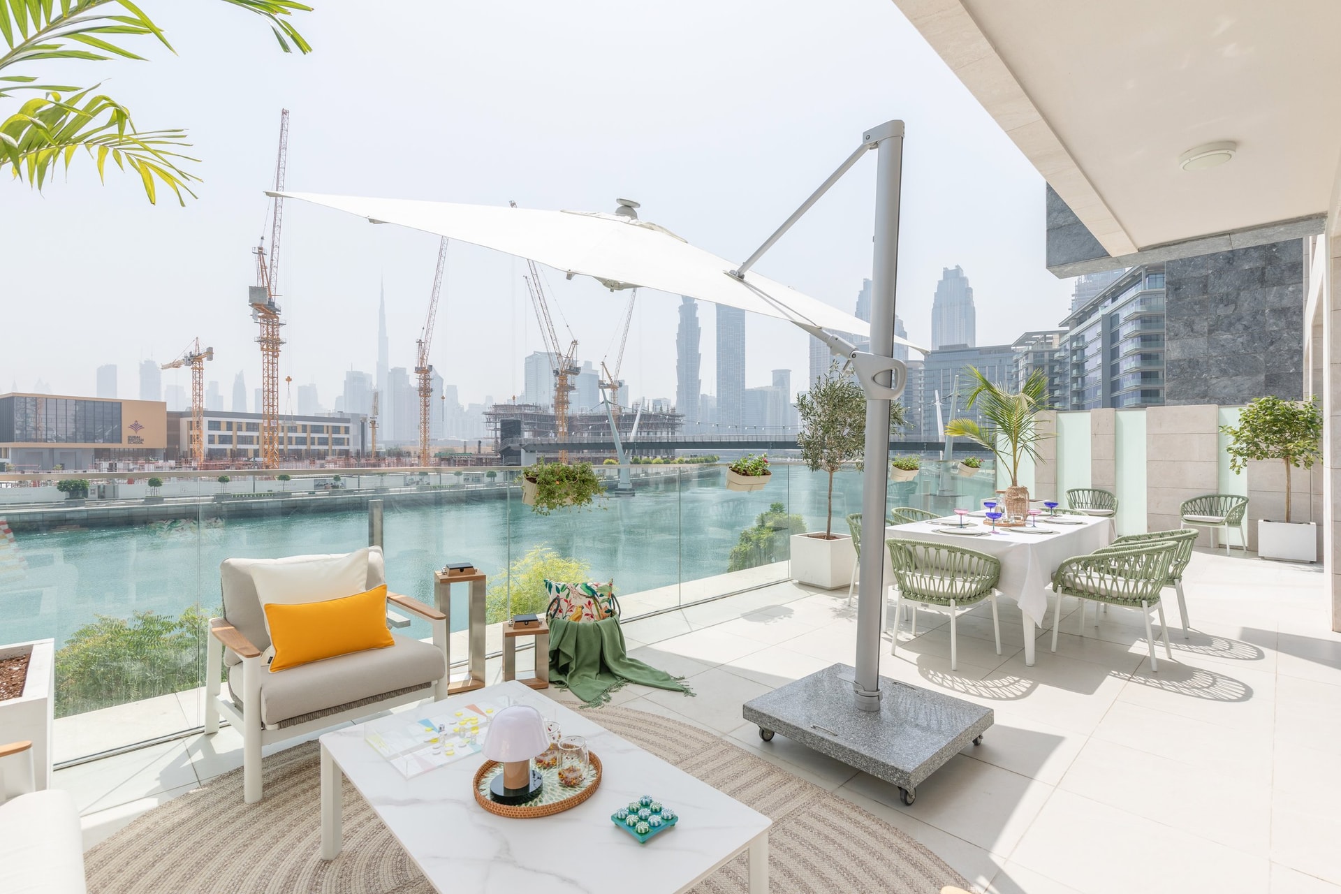 The wider terrace, split between a shaded dining zone and a lounge corner against the balustrade