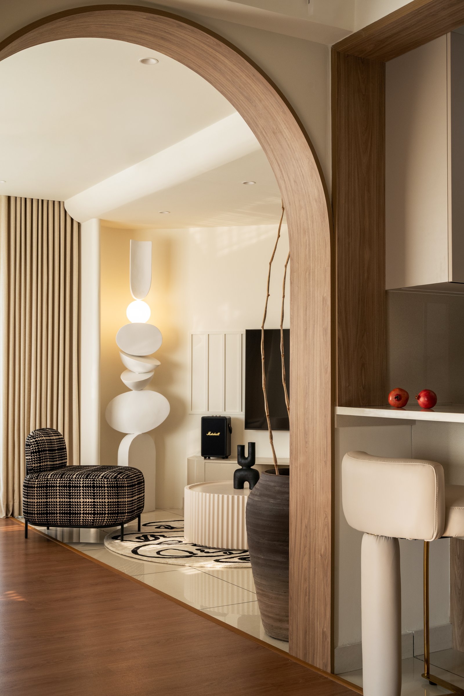 The arched wood-trimmed opening from the kitchen counter into the living room, threading continuity across functional zones