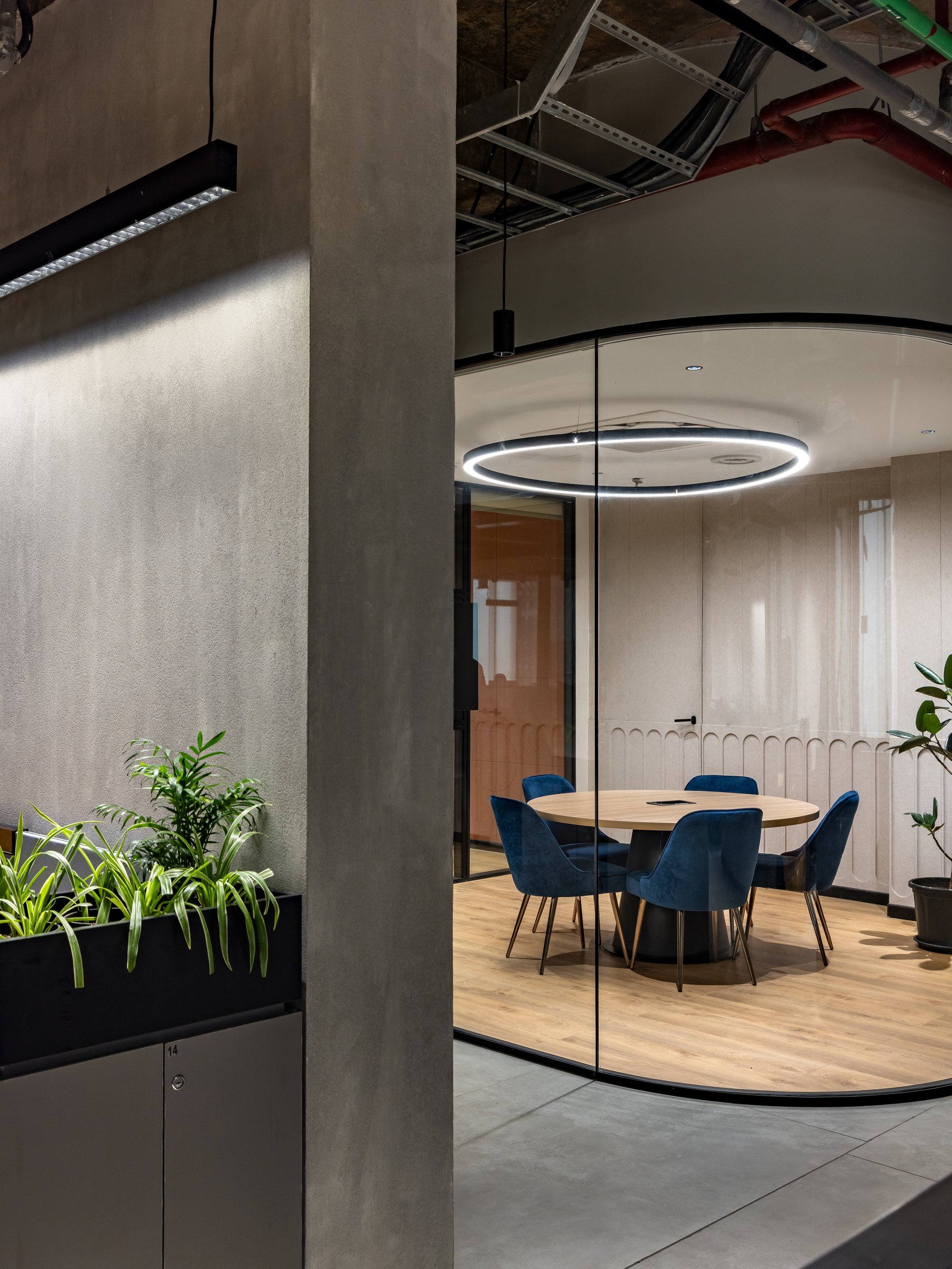 A second meeting room repeats the curved geometry behind an arched fabric-panel wall