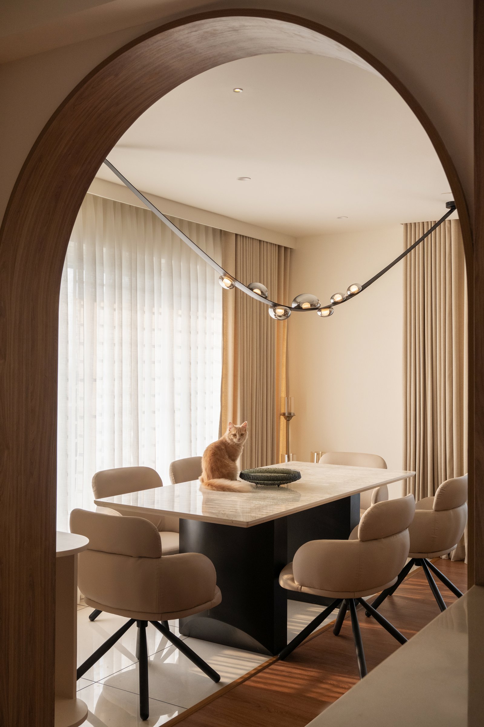 The dining room as tableau, framed through its arched threshold