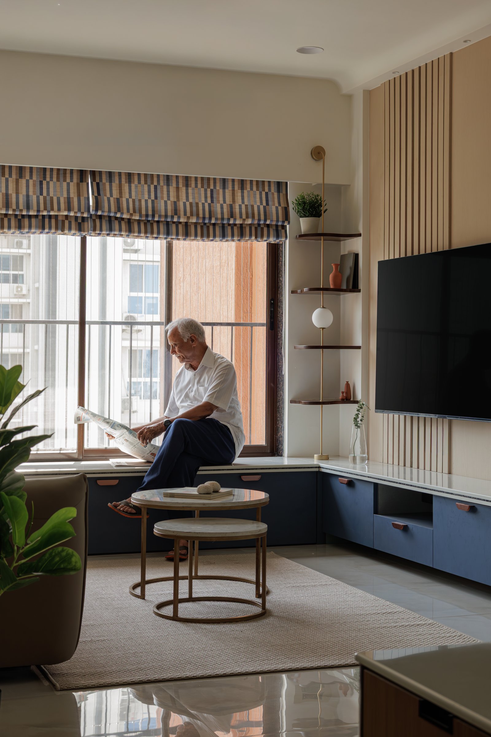 The living room window seat, designed for slow mornings, set against the slate-blue cabinetry that anchors the room