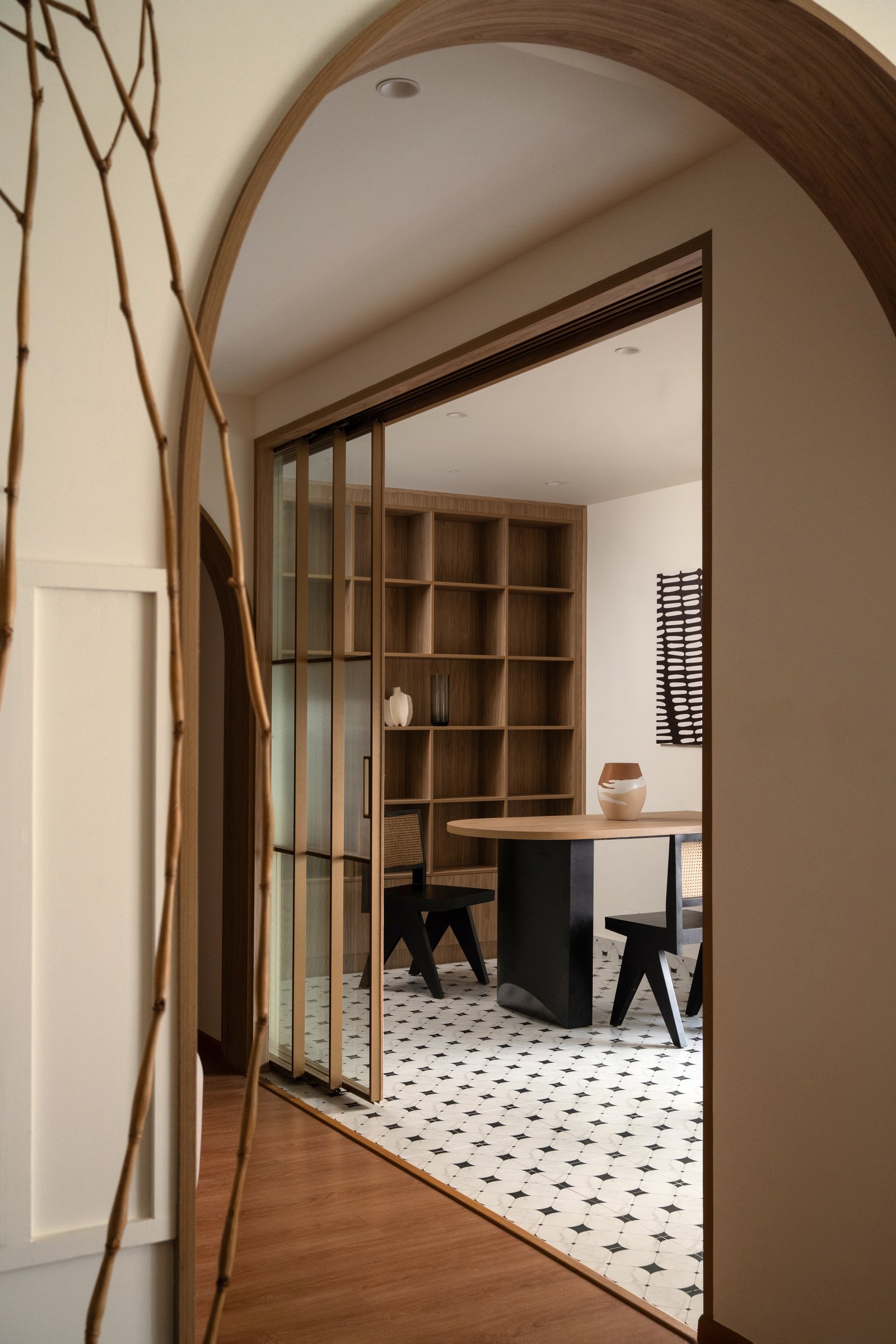 The arched threshold and sliding glass-and-wood partition that lets the multipurpose room open or close
