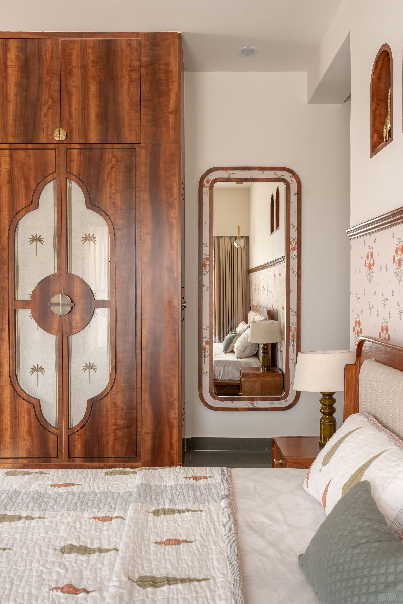 The dressing corner mirror, framing a small composition of bed, niches and pendant globe