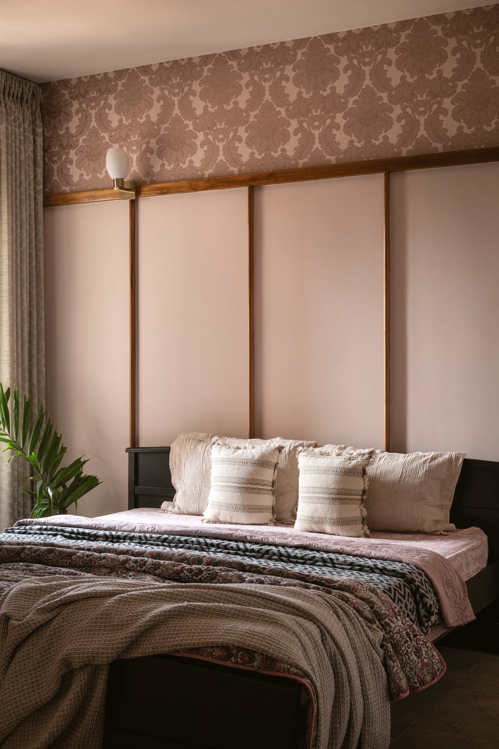 The master bedroom: a blush panelled wall capped with a damask wallpaper band, ornament held in restraint