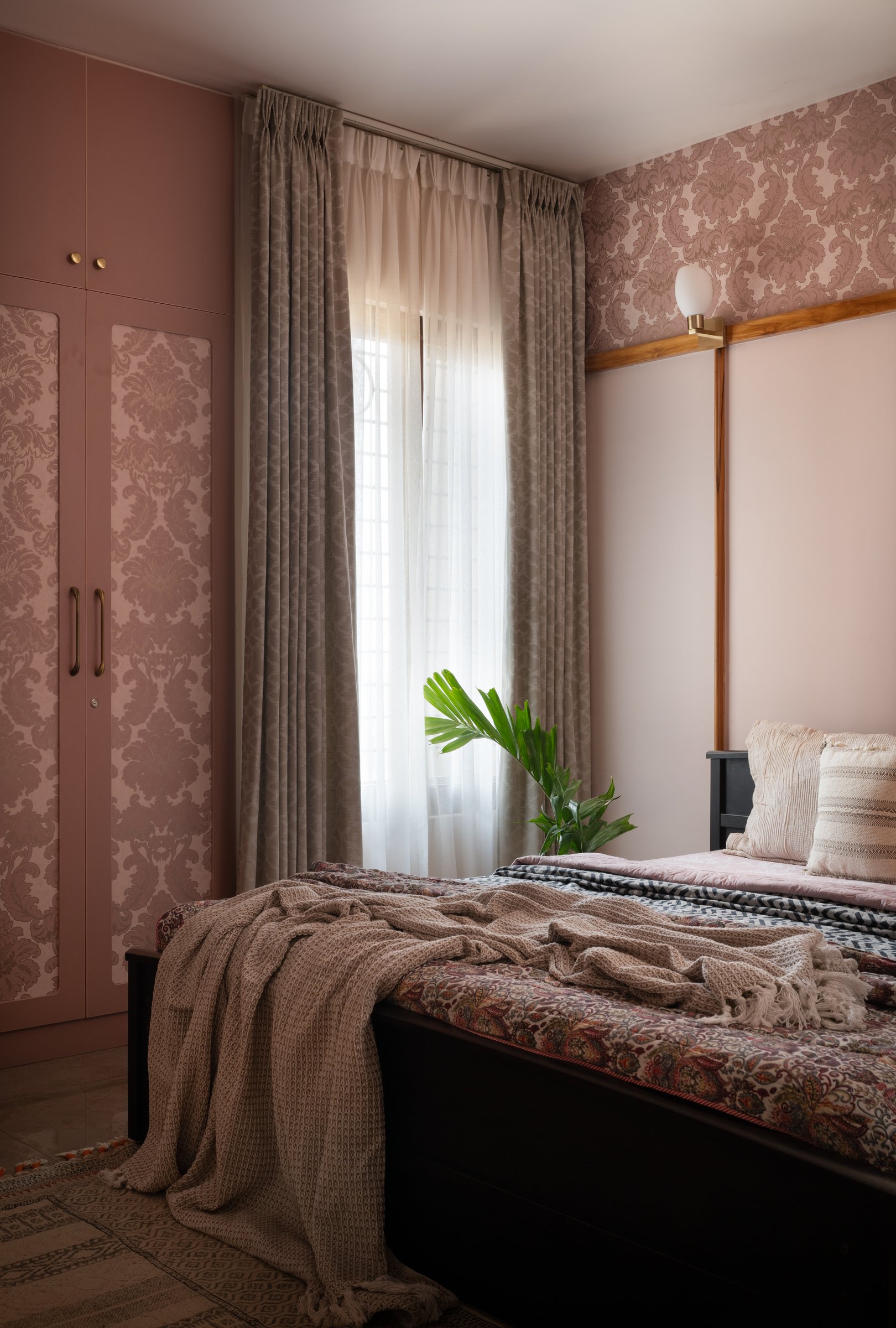 The damask-fronted wardrobe in deeper rose, with sheer curtains gentling the daylight