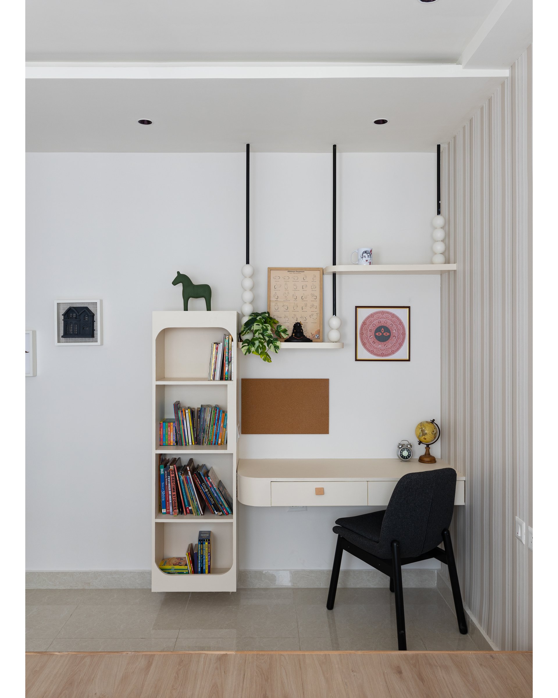 The study corner: wall-mounted desk, rounded-opening bookshelf, and a wooden Dala horse as Nordic reference
