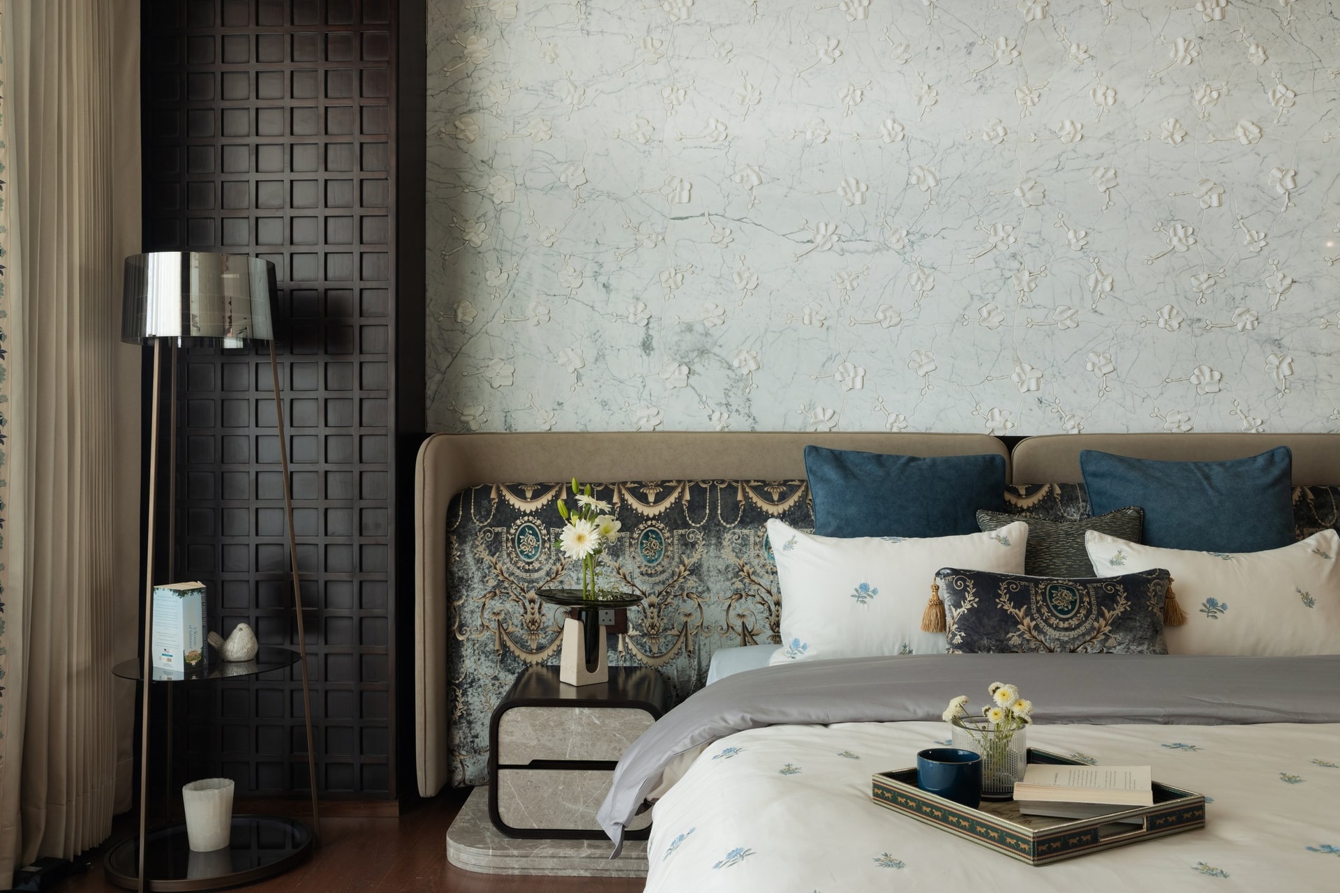 The custom headboard wall, the project's clearest expression of panelling, fabric, lighting, and millwork resolved as a single element
