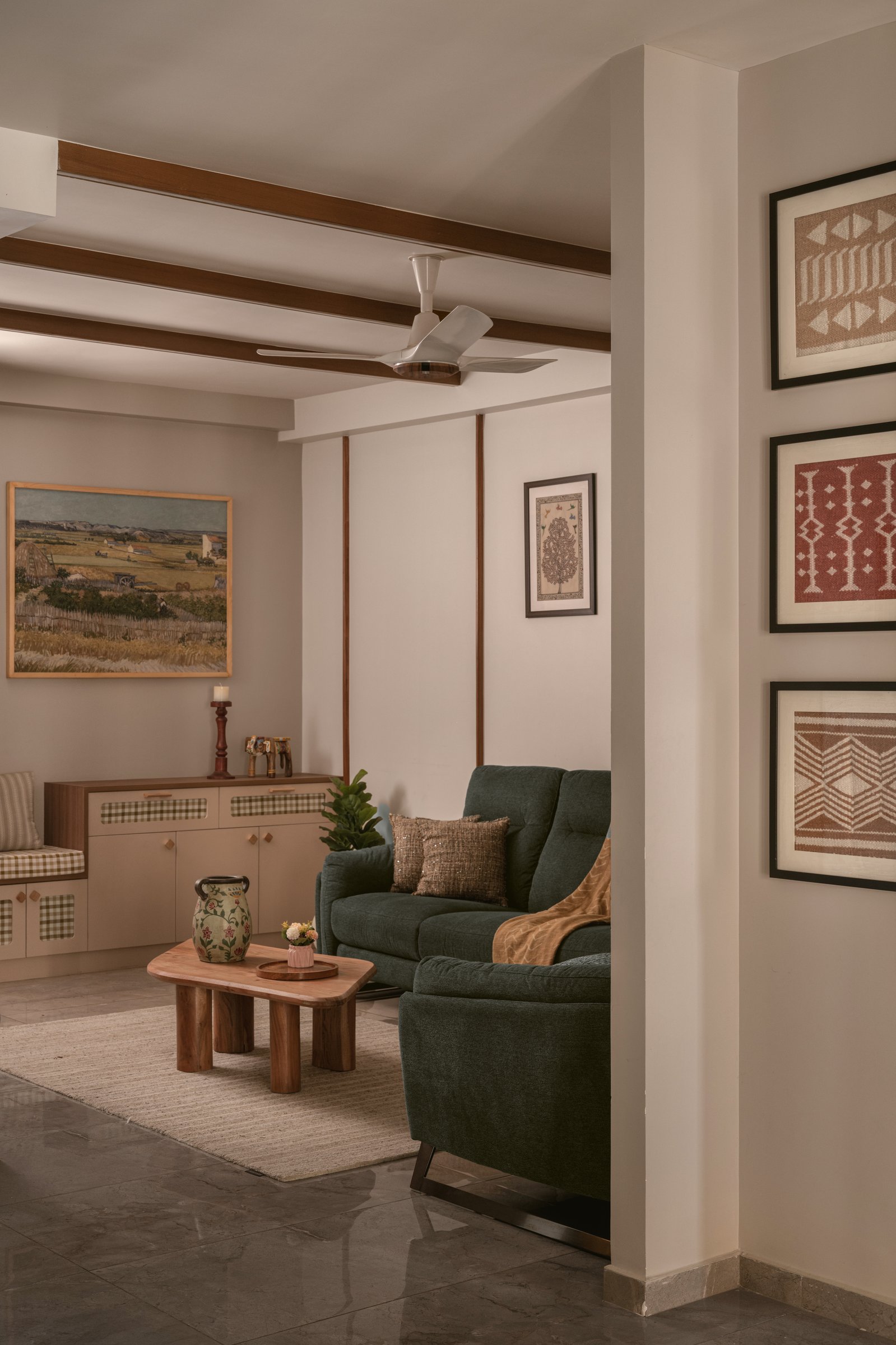 The living area's gingham-fronted storage console, with a reproduction Van Gogh harvest landscape extending the earthen palette