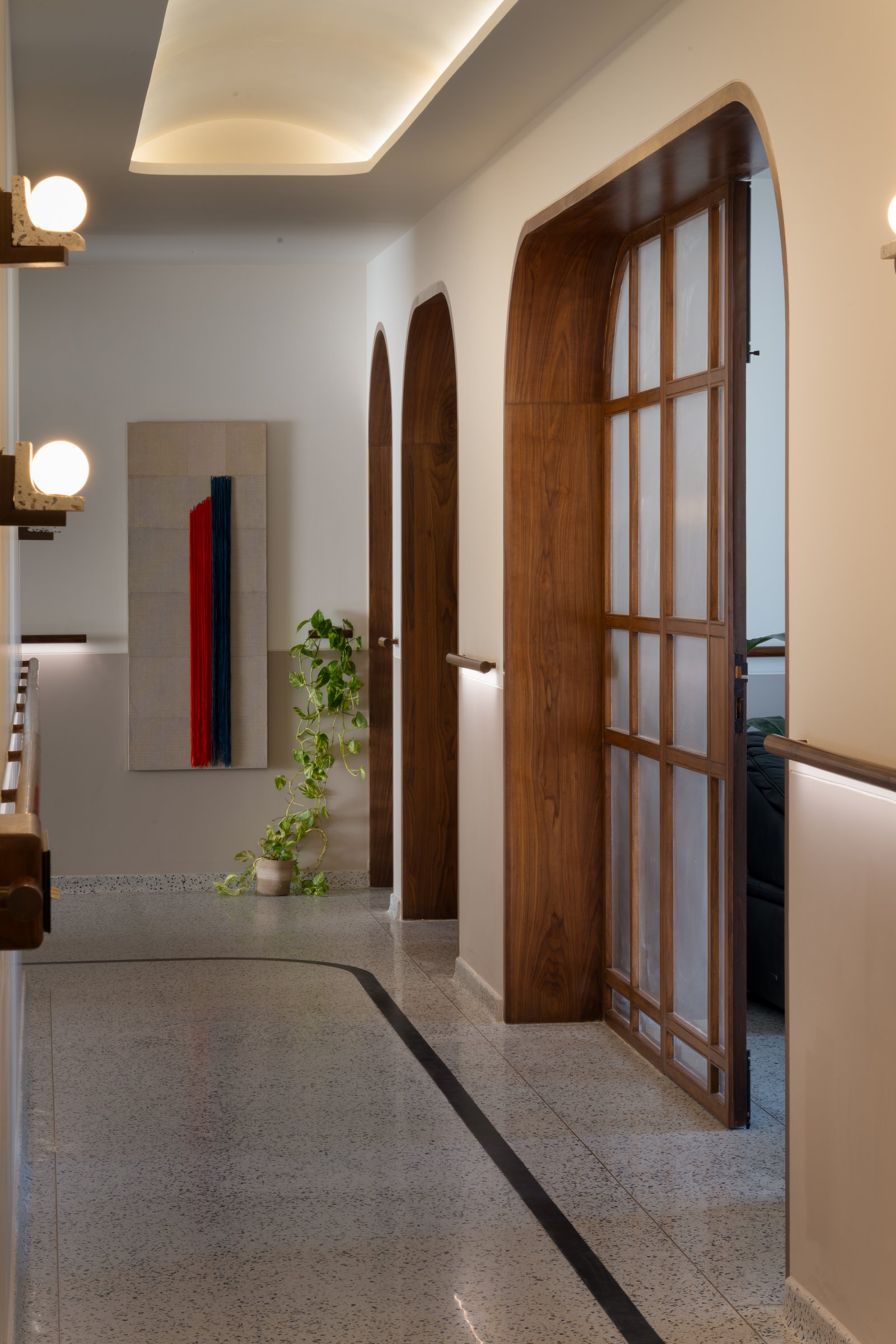 The bedroom corridor, treated as a room in its own right with twin arched doors and a textile artwork