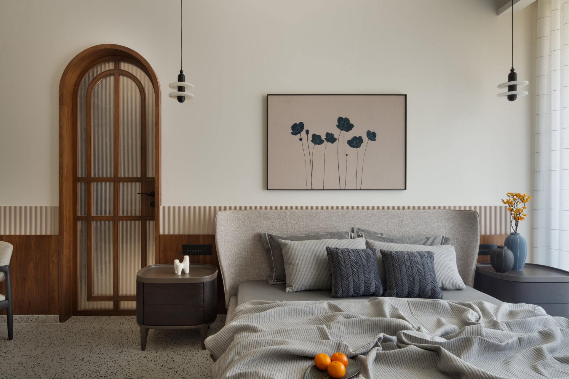 The second bedroom, softer in register with a reeded pale-wood dado and a fluted-glass arched door