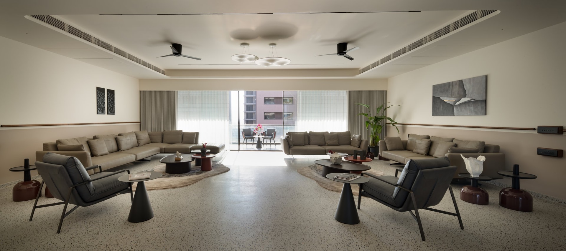 The living room, twin seating clusters mirrored across a central axis toward the balcony
