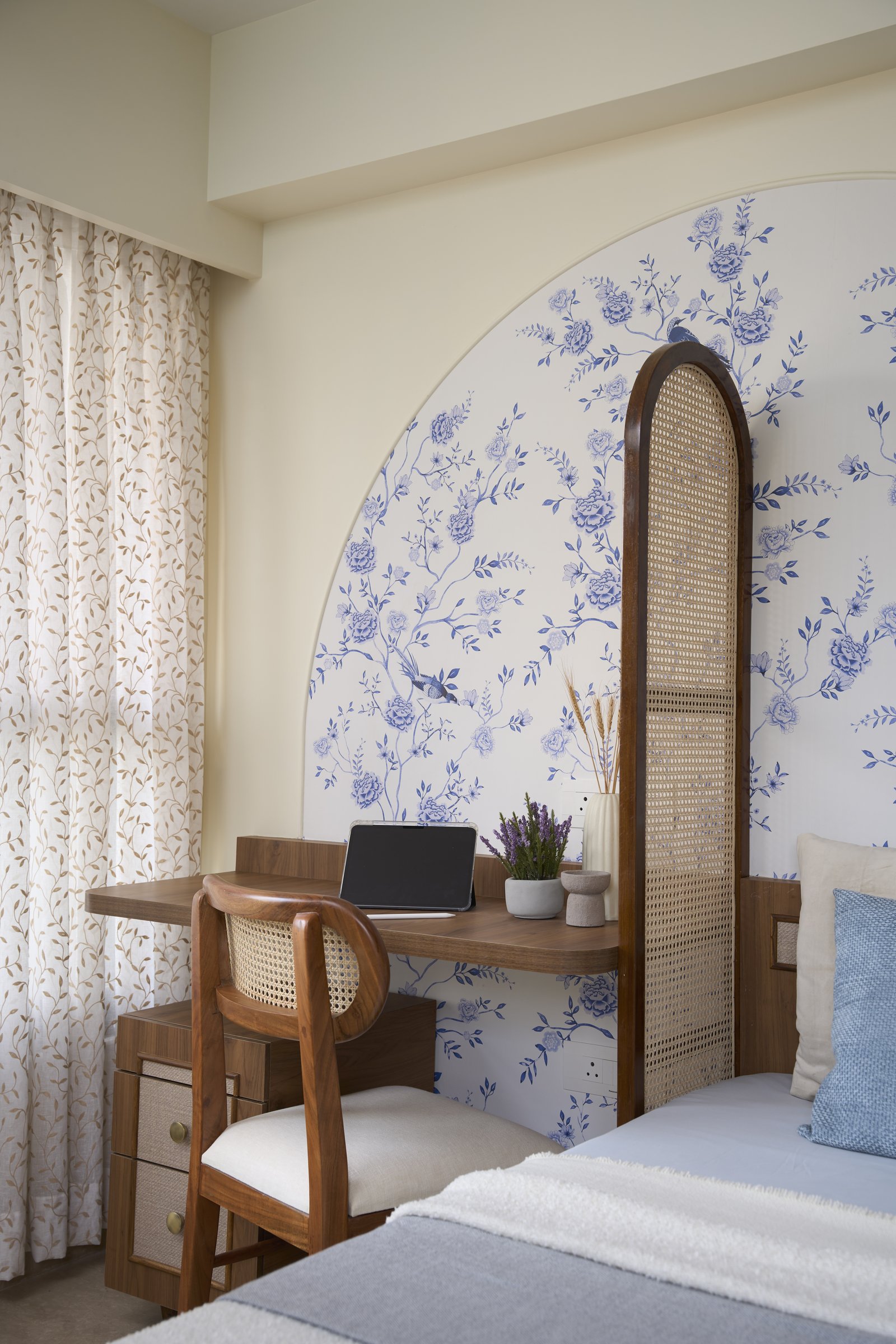 A built-in study desk extends from the bed, separated only by a slim arched cane screen